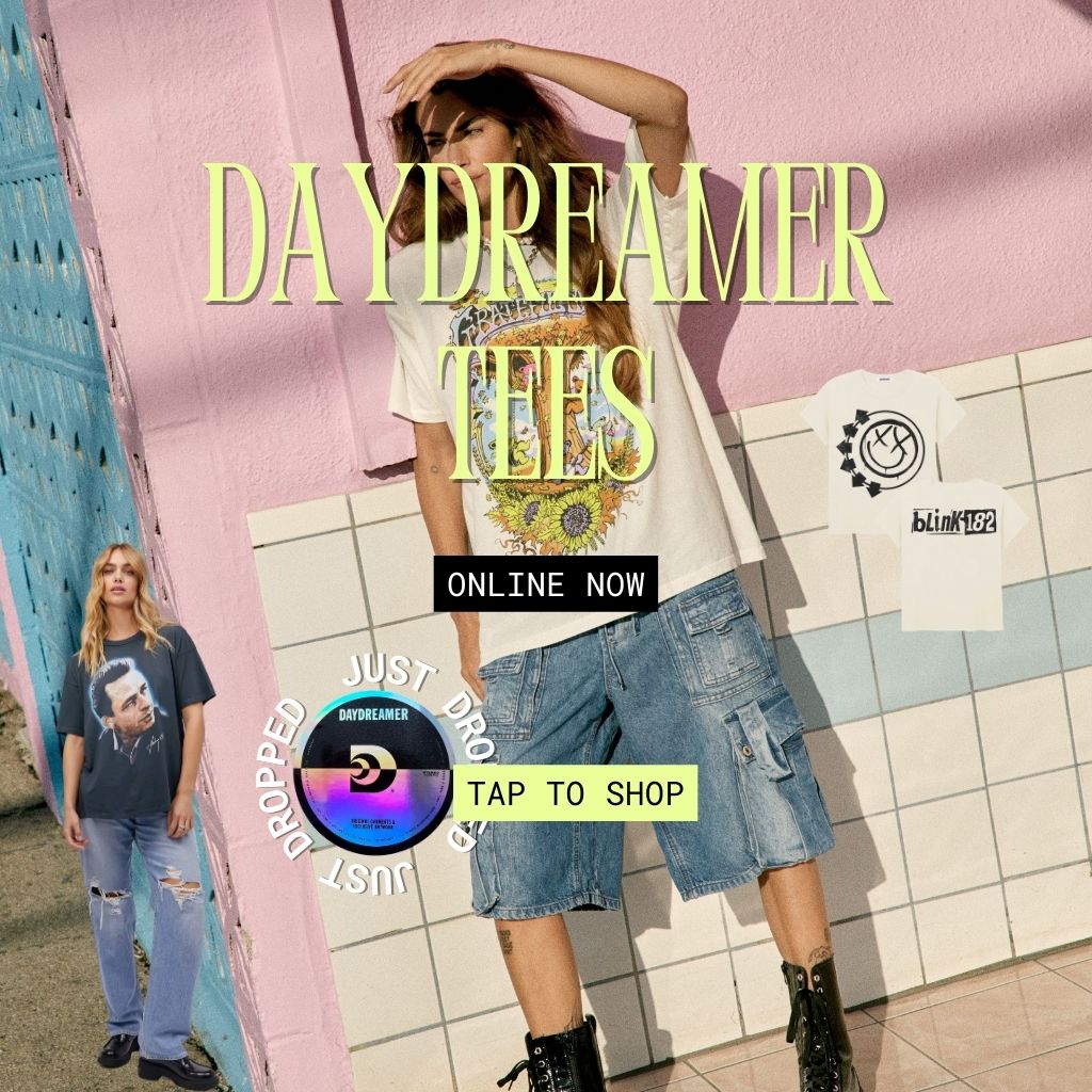 Daydreamer graphic t-shirt advertisement image with a woman wearing a Grateful Dead t-shirt by Daydreamer standing in front of a pink wall with combat boots on. 