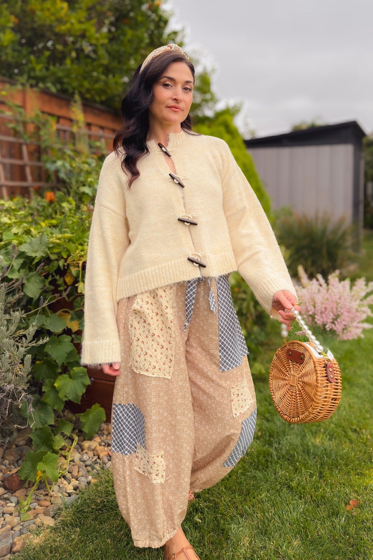 Close-up of beige floral patchwork balloon pants showing mixed-print patch details, elastic waistband, roomy fit and gathered ankle cuffs.