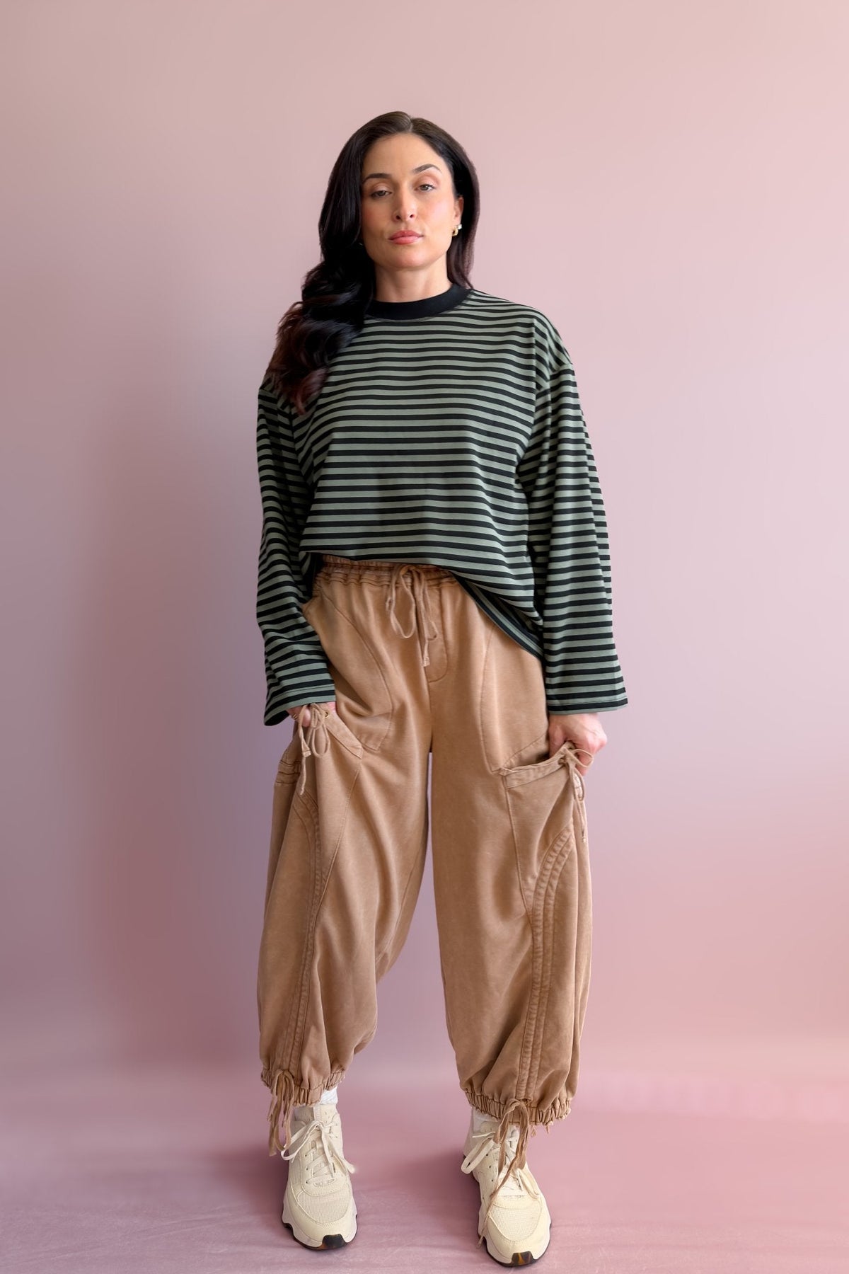 Black and olive boxy striped tee styled with white wide-leg jeans and neutral sneakers