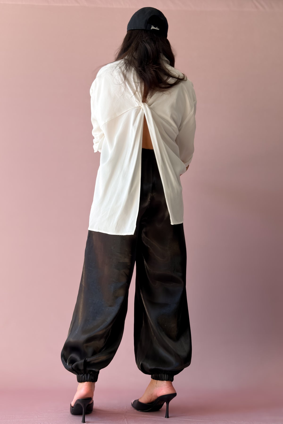 Black balloon jogger pants styled with heels and layered black and ivory top