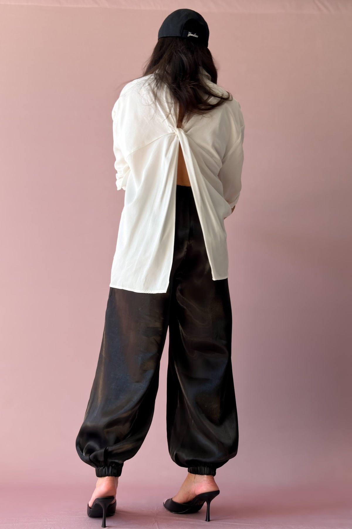 Black balloon jogger pants styled with heels and layered black and ivory top