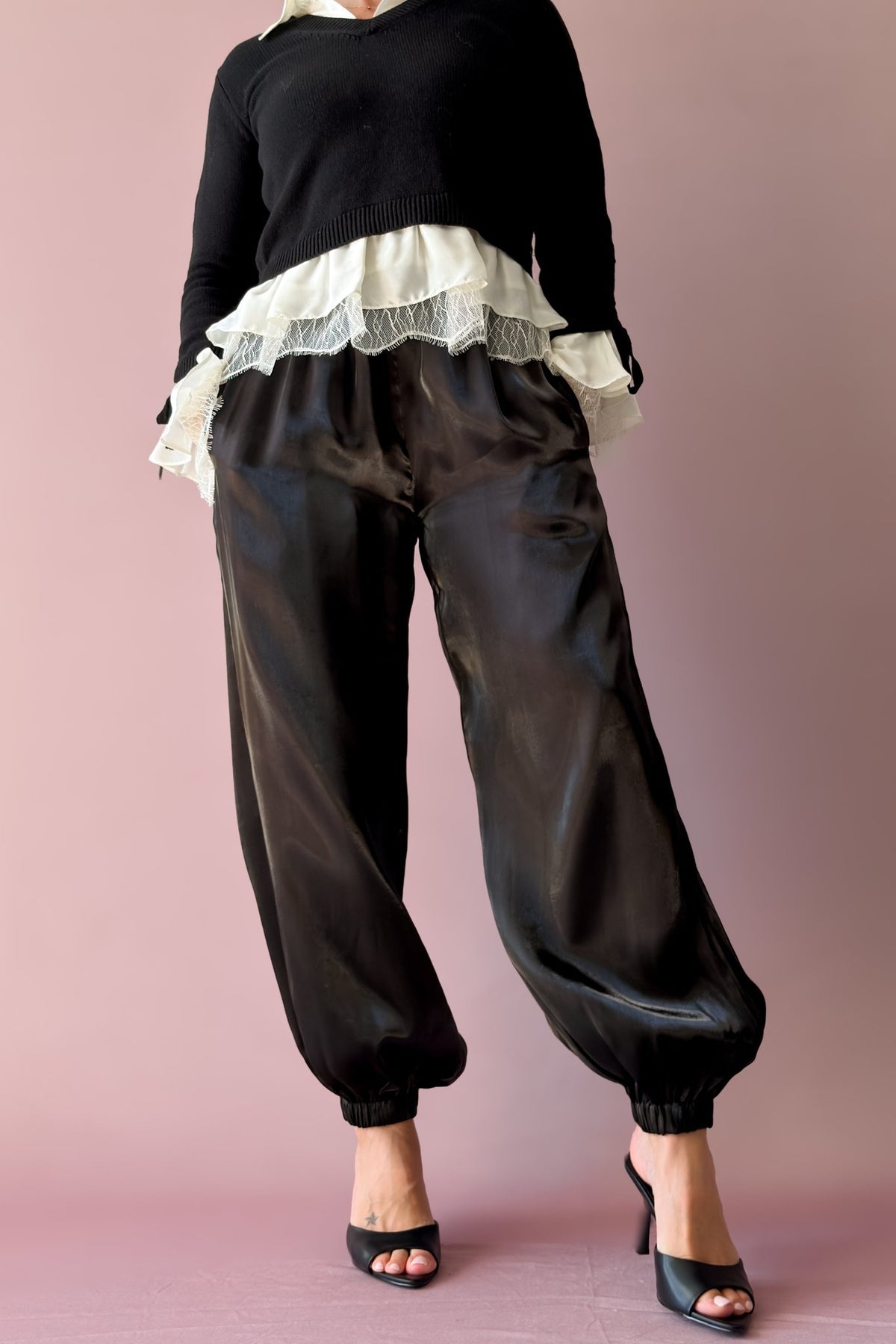 Black statement jogger pants styled with heels for an elevated casual outfit