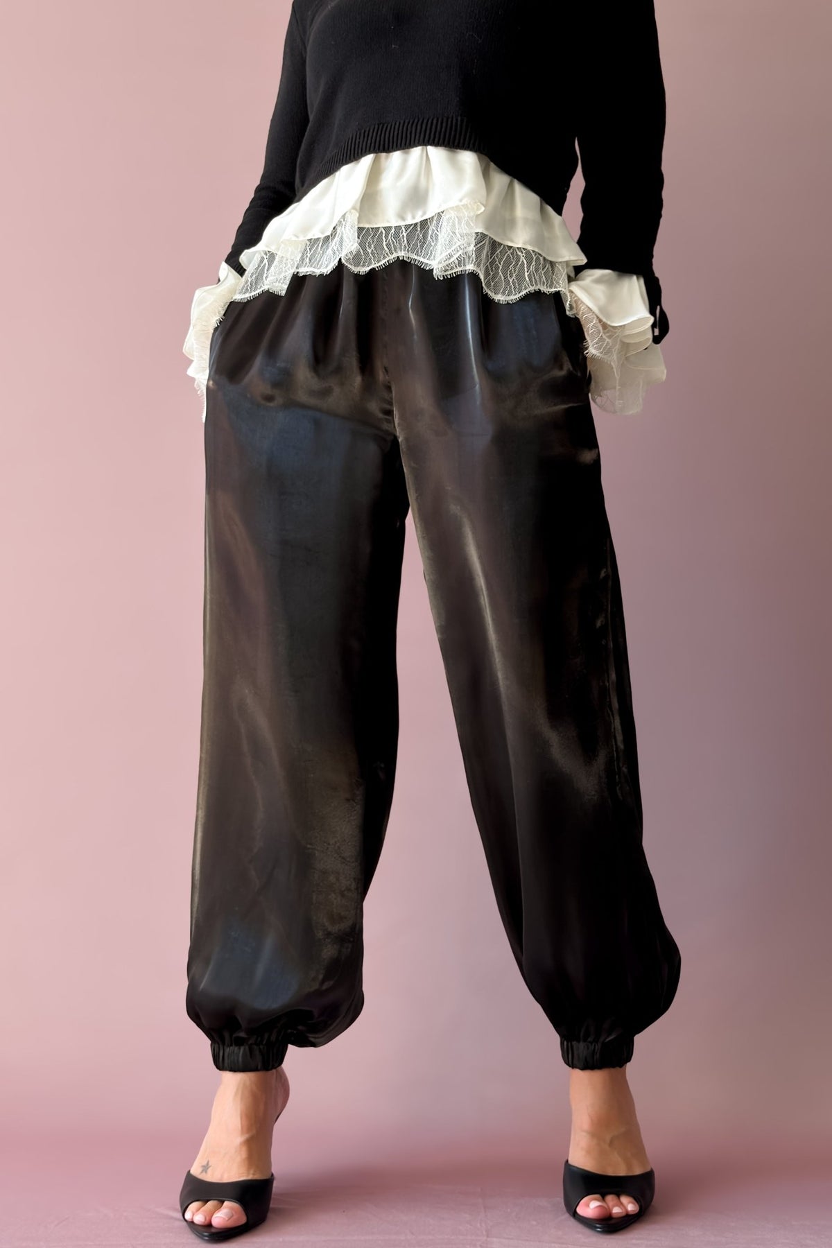 Close-up of black organza jogger pants showing lustrous fabric and tapered ankle