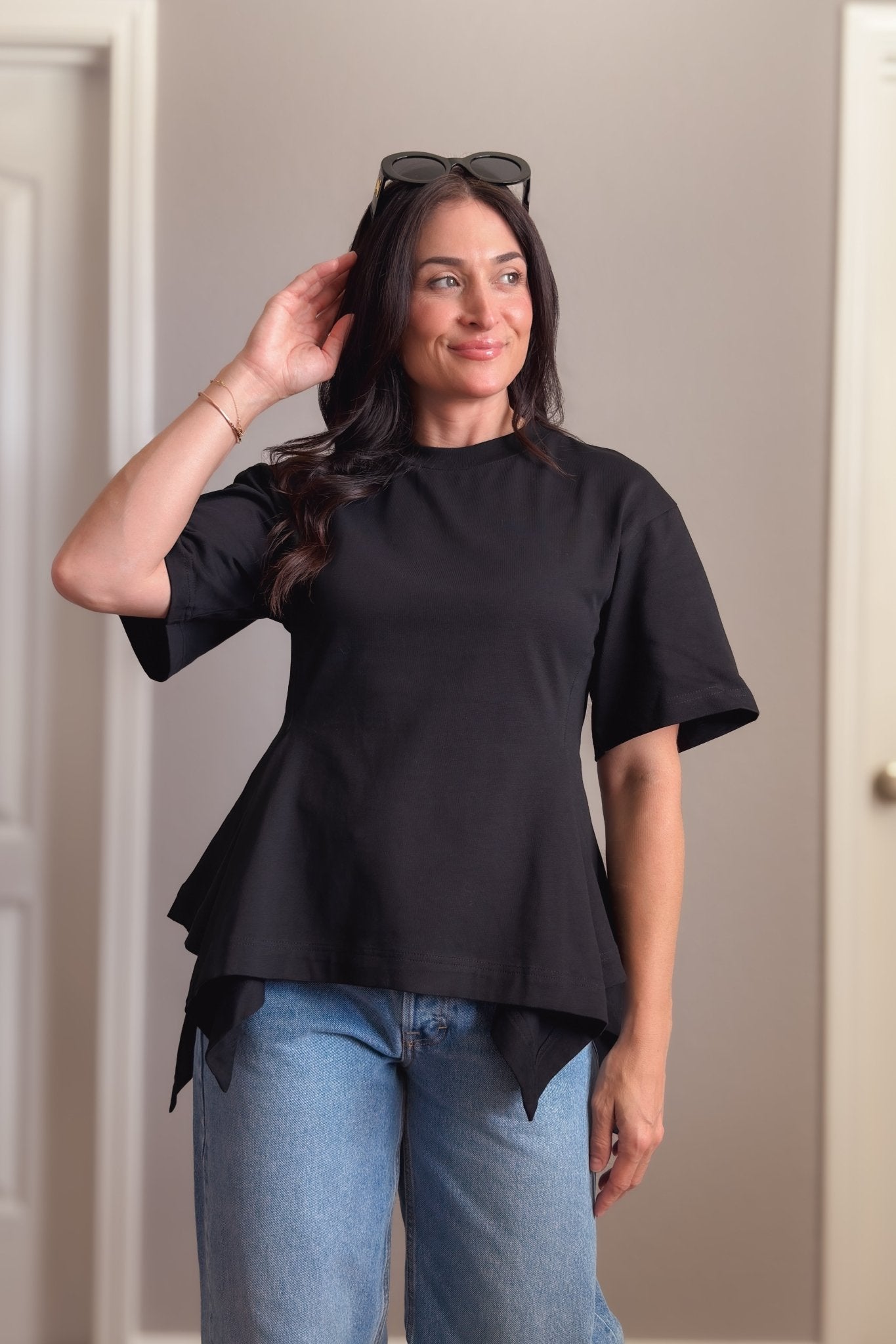 Black structured cotton peplum T-shirt with oversized short sleeves and a flattering waist-defining fit.