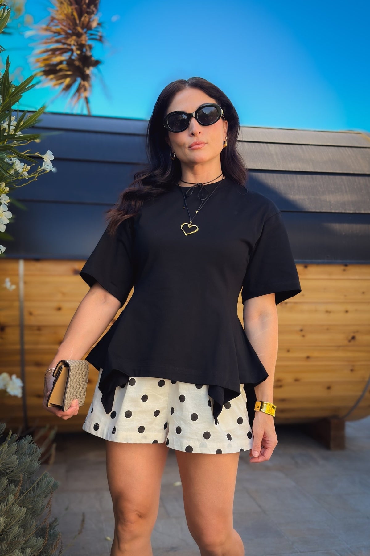 Women’s black structured peplum top with relaxed short sleeves and a flattering waist-shaping silhouette.