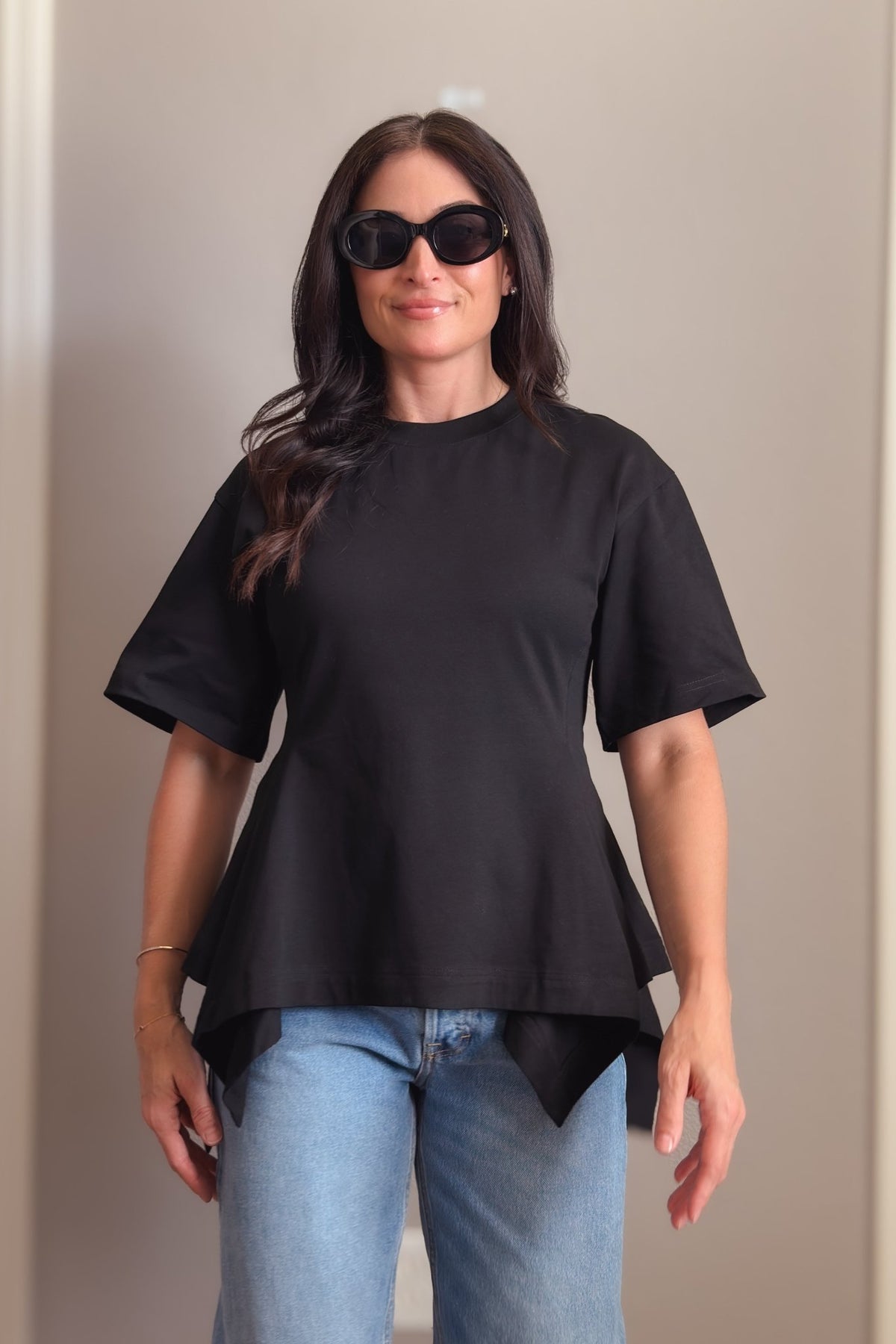 Black structured cotton peplum T-shirt with oversized short sleeves and a flattering waist-defining fit.