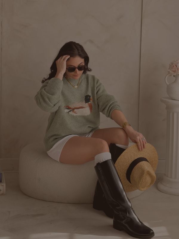 Blooming Daily women’s boutique outfit featuring sage green duck sweater styled with boots and straw hat for elevated everyday fashion