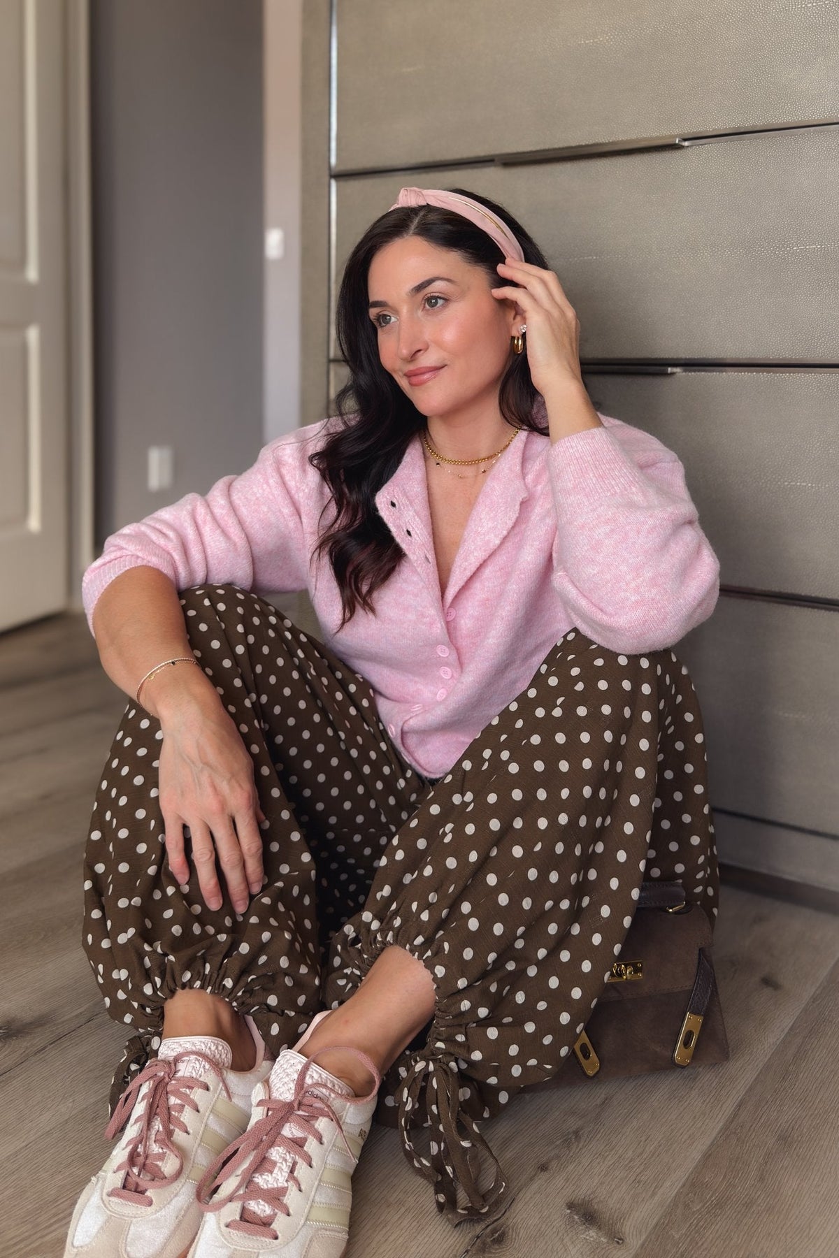 Women’s soft pink knit cardigan with functional buttons, relaxed fit, and ribbed trim styled for an everyday feminine outfit.