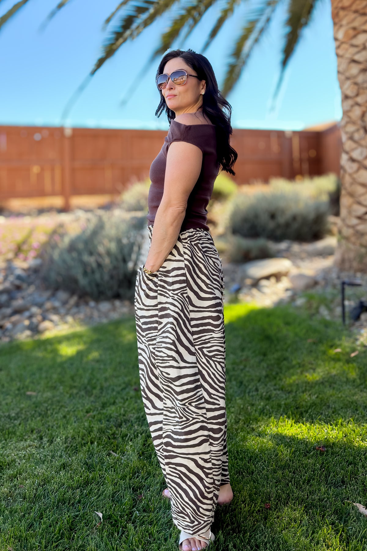 Brown zebra print French terry barrel pants paired with a fitted black top and neutral accessories for an elevated casual look.