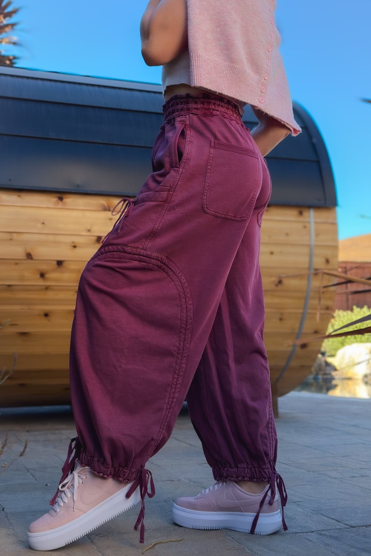Women’s burgundy cargo pants with relaxed wide leg fit, elastic waistband and adjustable ankle ties