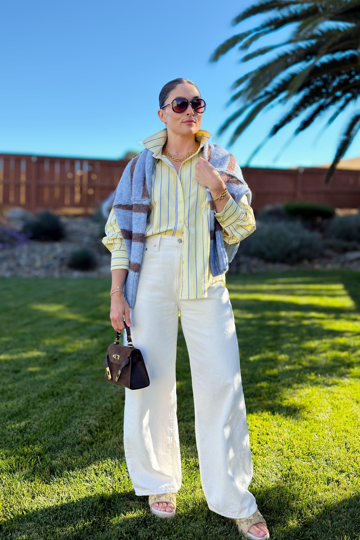 Light yellow and blue striped button down shirt with a structured cotton feel, curved hem, and timeless everyday style.