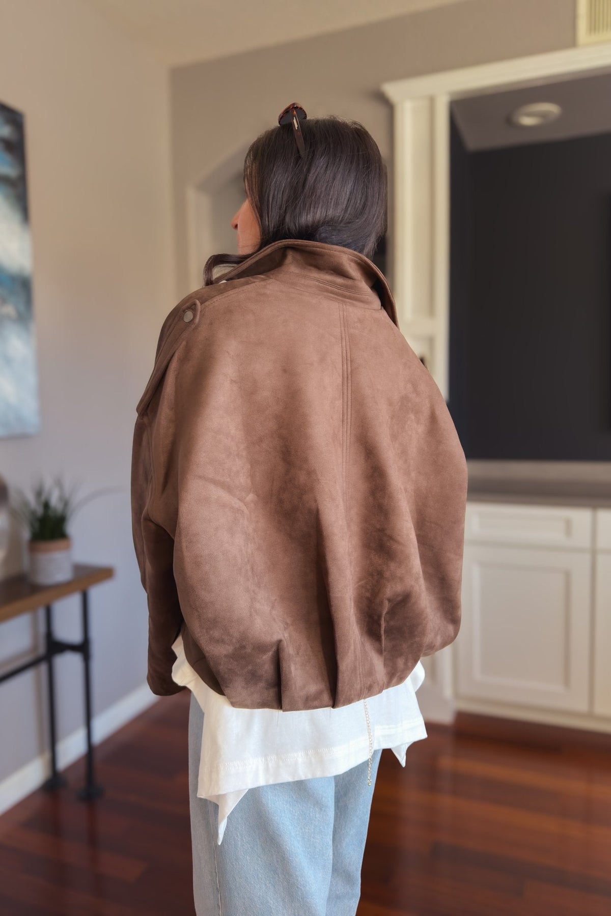 Back view of chocolate brown faux suede bomber jacket showing the relaxed oversized shape and smooth microsuede finish.