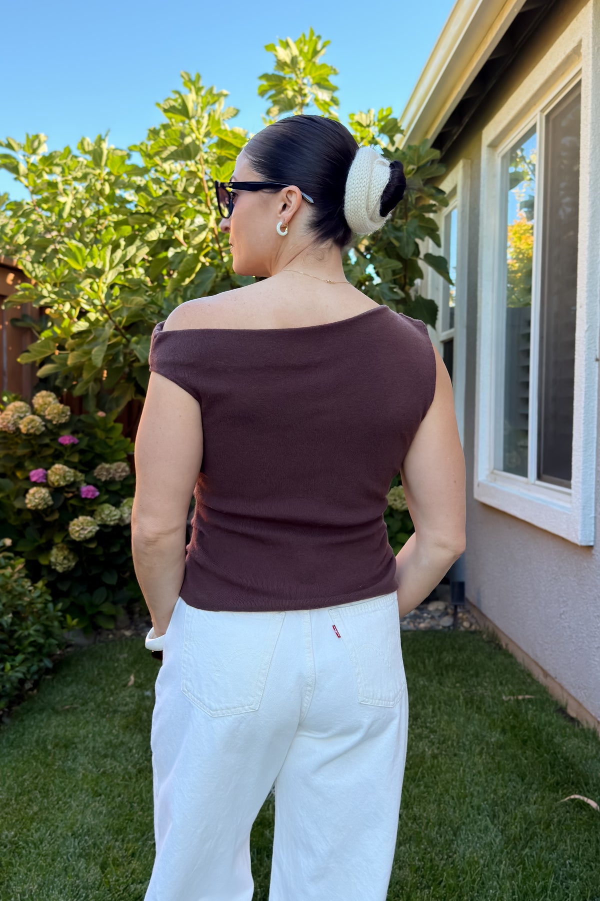 Side profile of a fitted chocolate brown knit top with an off shoulder neckline and comfortable stretch-to-fit design.