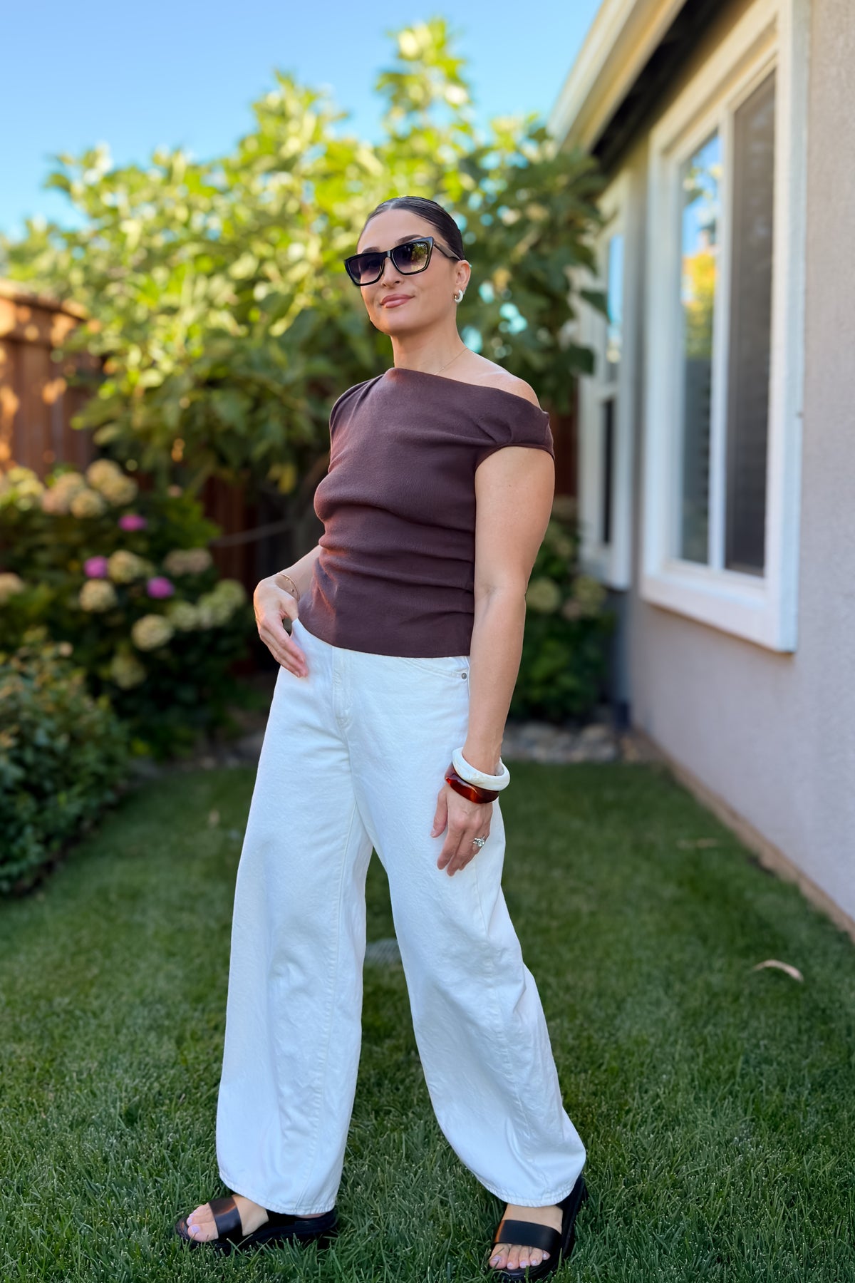 Chocolate brown off shoulder knit top paired with white wide leg jeans for a timeless everyday outfit.