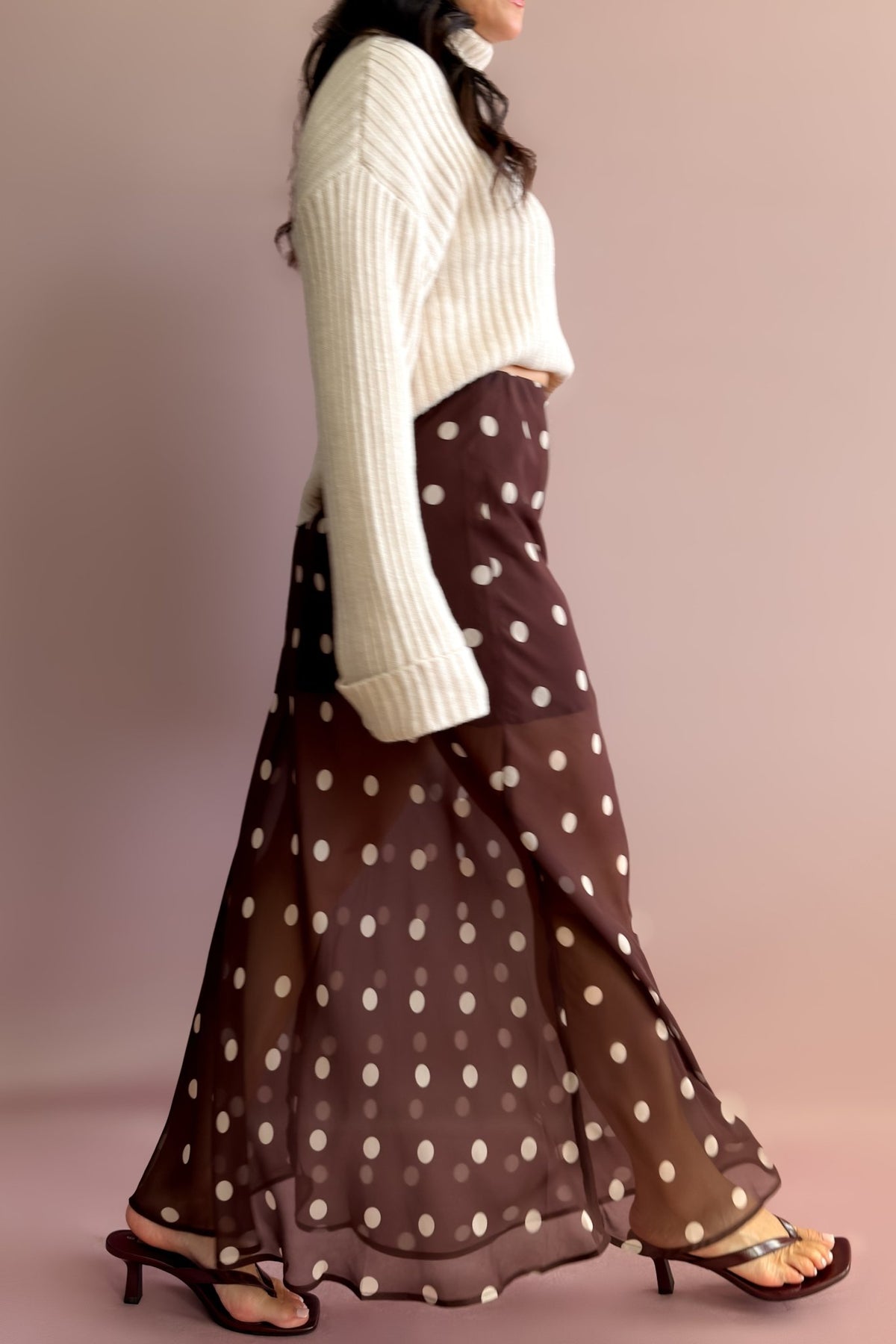 Women’s sheer polka dot maxi skirt in chocolate brown styled with a neutral turtleneck sweater and heeled sandals