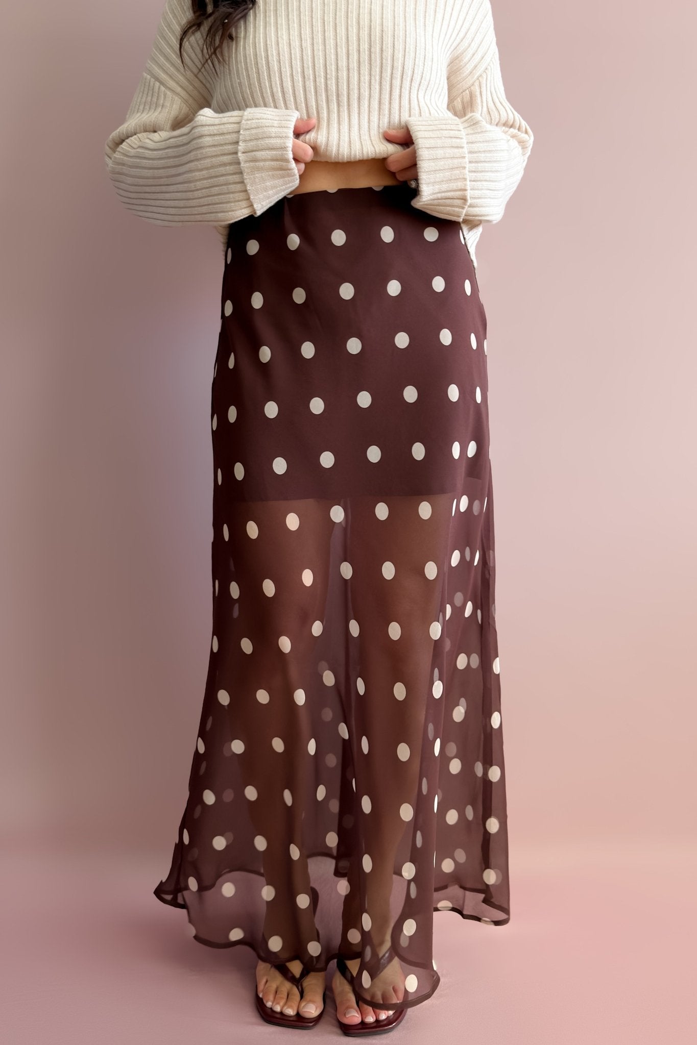 Chocolate brown polka dot sheer maxi skirt with cream spots, partial lining, and flowing floor-length silhouette