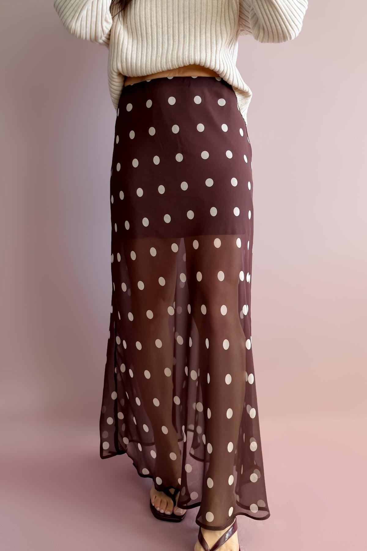 Close-up of chocolate brown polka dot maxi skirt showing the soft elastic waist and partially lined sheer design