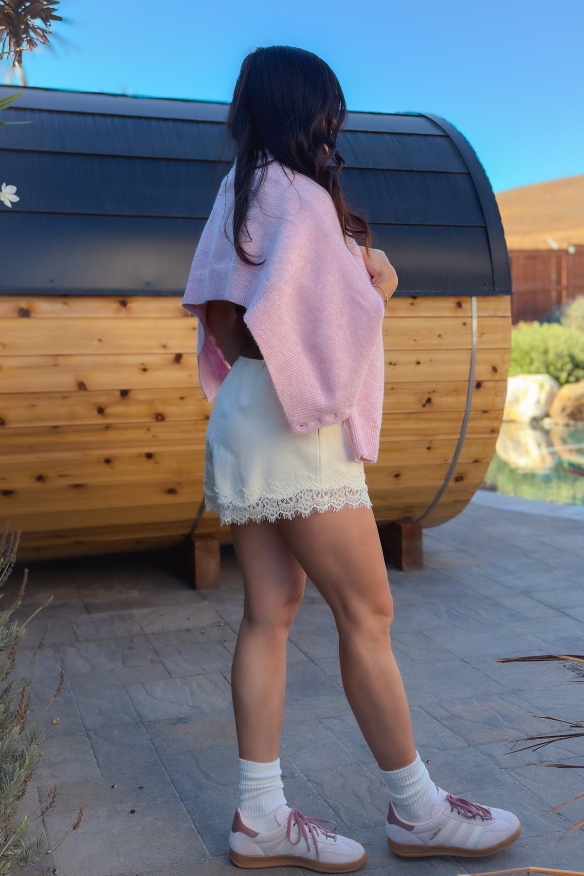 1. Flat lay of cream French terry lace trim shorts with pink cardigan, sneakers and socks
