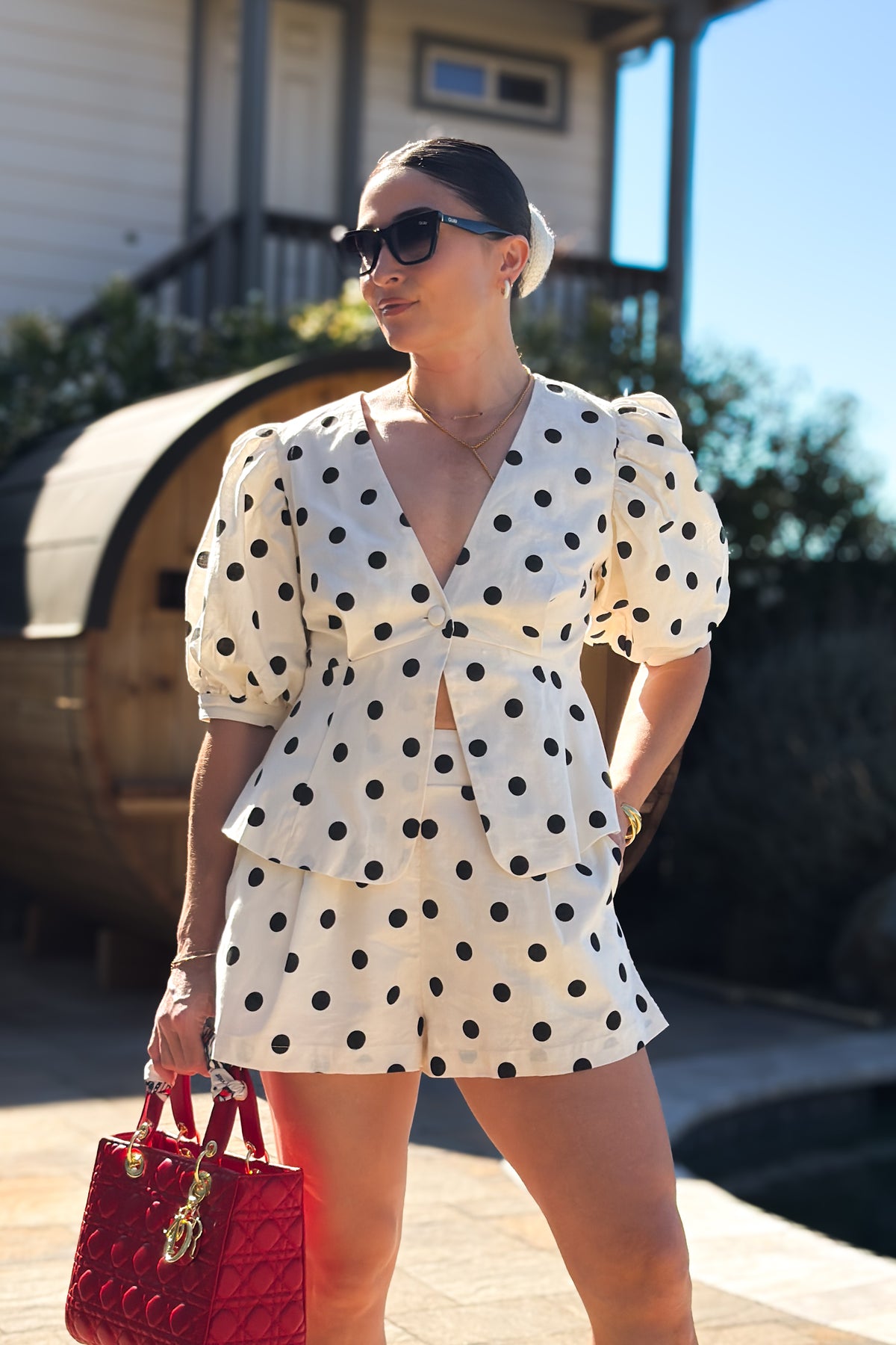 Woman wearing a cream linen blend short set with a peplum top, puff sleeves, and matching high-waisted shorts for an elevated summer outfit.