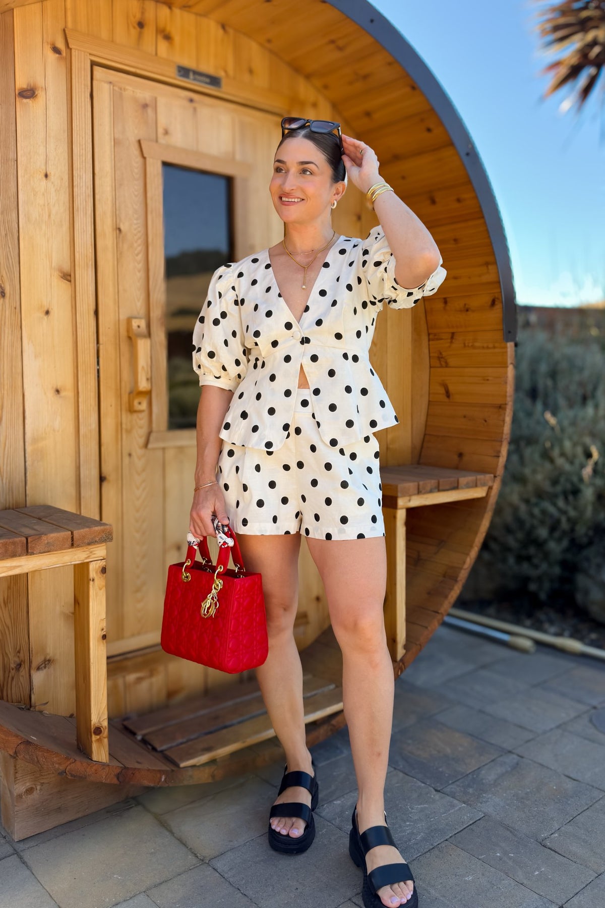 Women's cream linen blend outfit with a fitted peplum top and relaxed shorts designed with a soft smocked waistband.