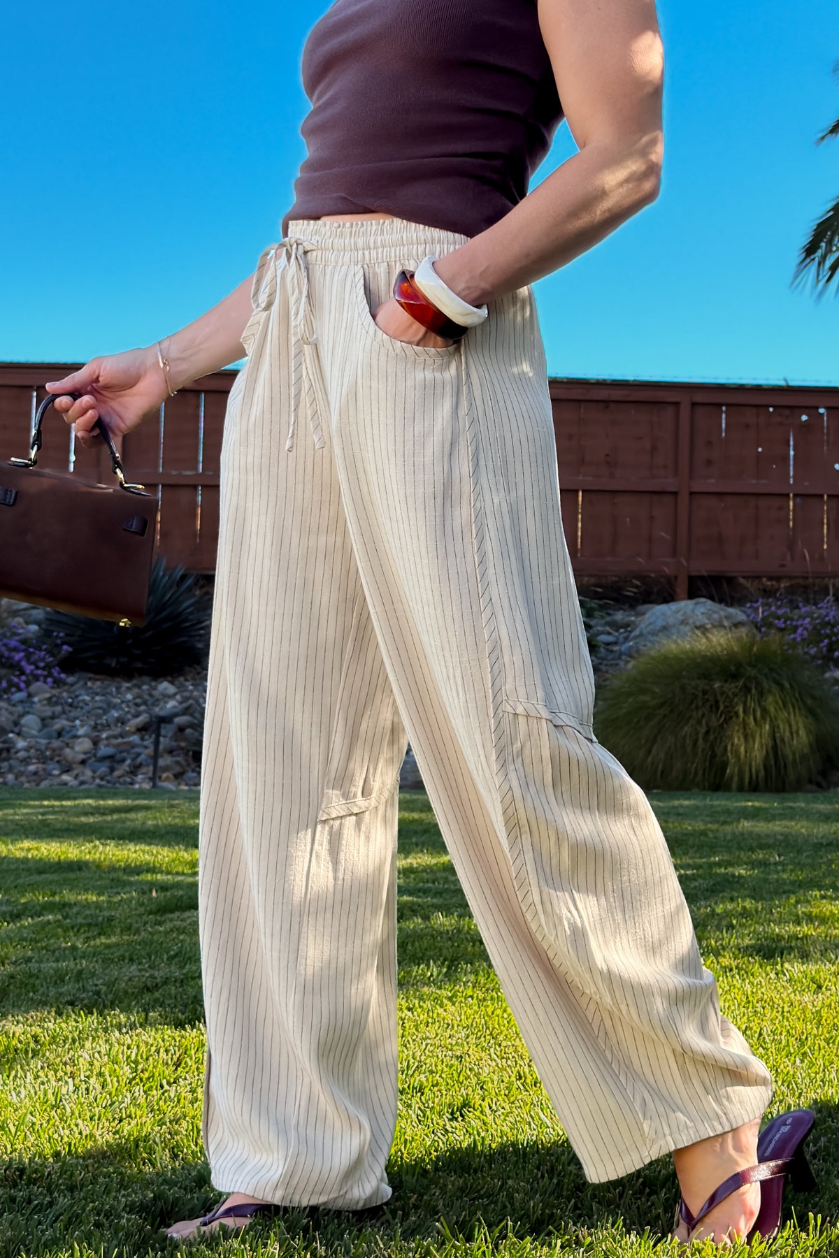 Close-up of cream striped linen blend pants featuring a stretchy pull-on waist, drawstring, and lightweight texture.