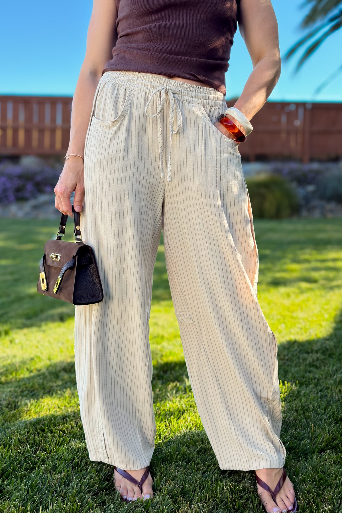 Cream striped pull-on pants with a breezy wide leg fit, soft elastic waistband, and casual everyday styling.