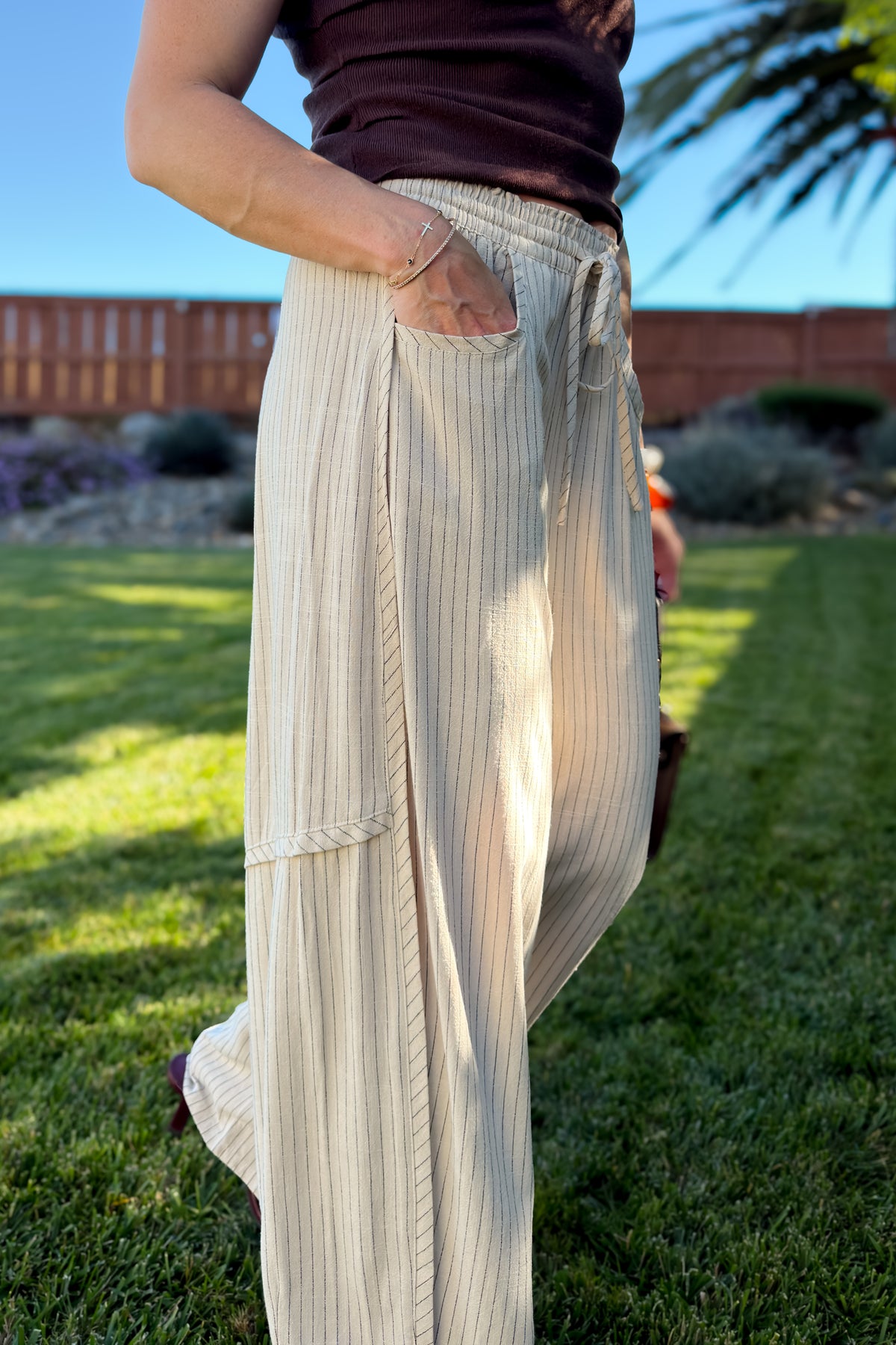 Front view of cream striped wide leg pants featuring a soft elastic waistband, adjustable drawstring, and relaxed fit.