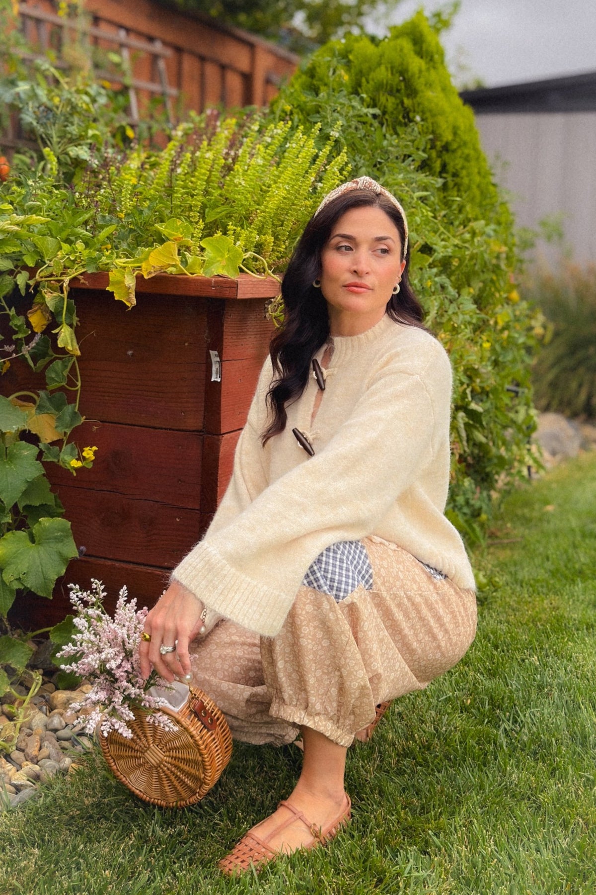 Soft cream cardigan with wooden toggle closures styled over beige floral patchwork balloon pants for a feminine everyday outfit.