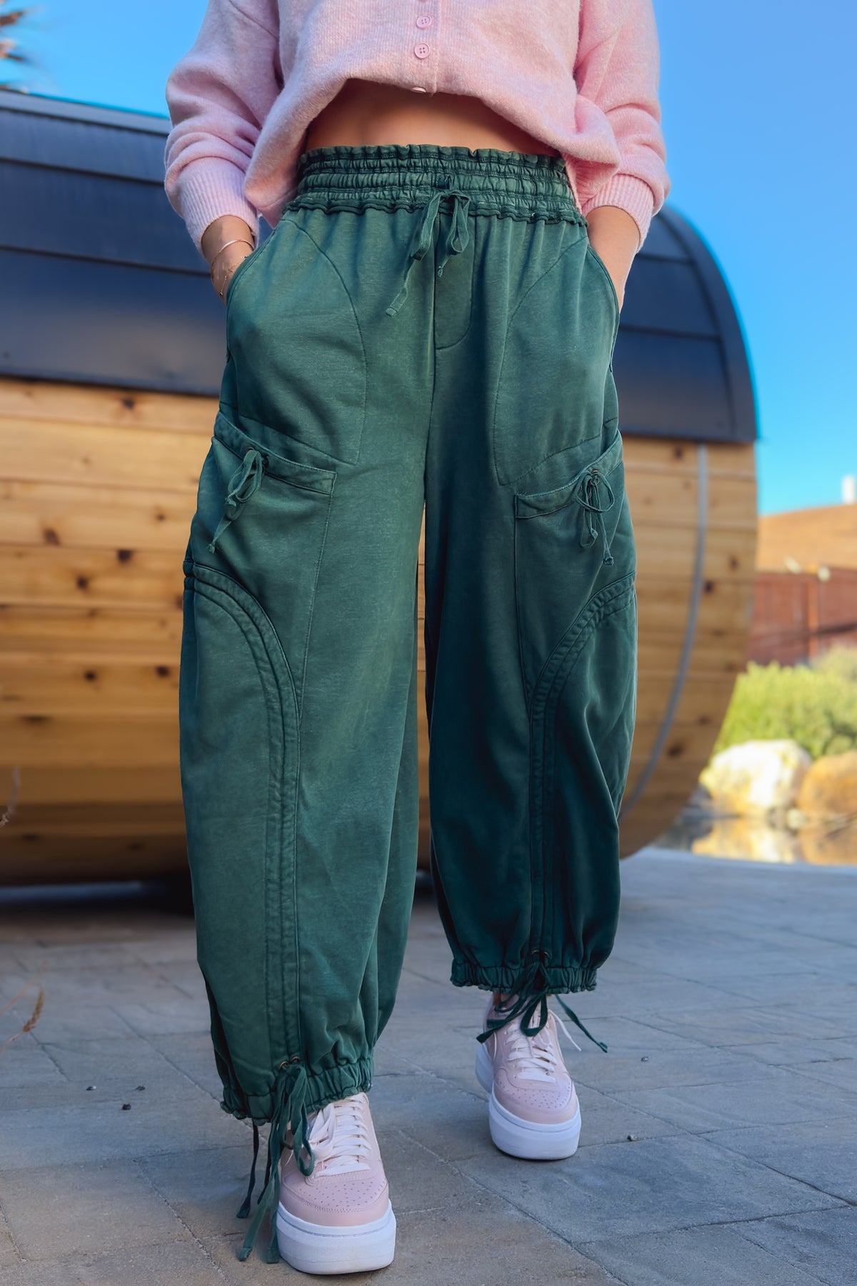 Green mineral wash wide leg cargo pants for women styled with pink cardigan and sneakers