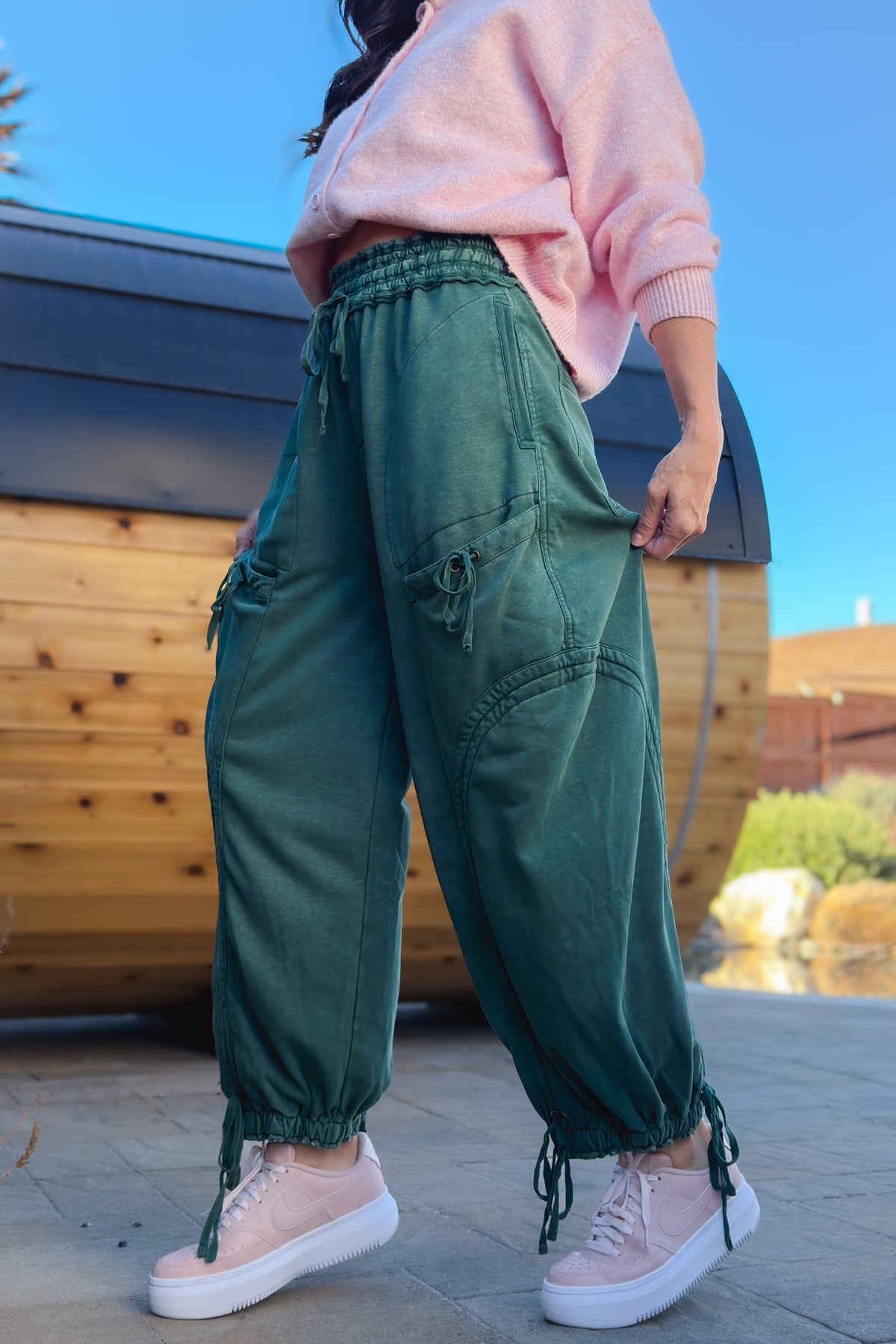 Back view of green mineral wash cargo pants with functional back pockets and oversized fit