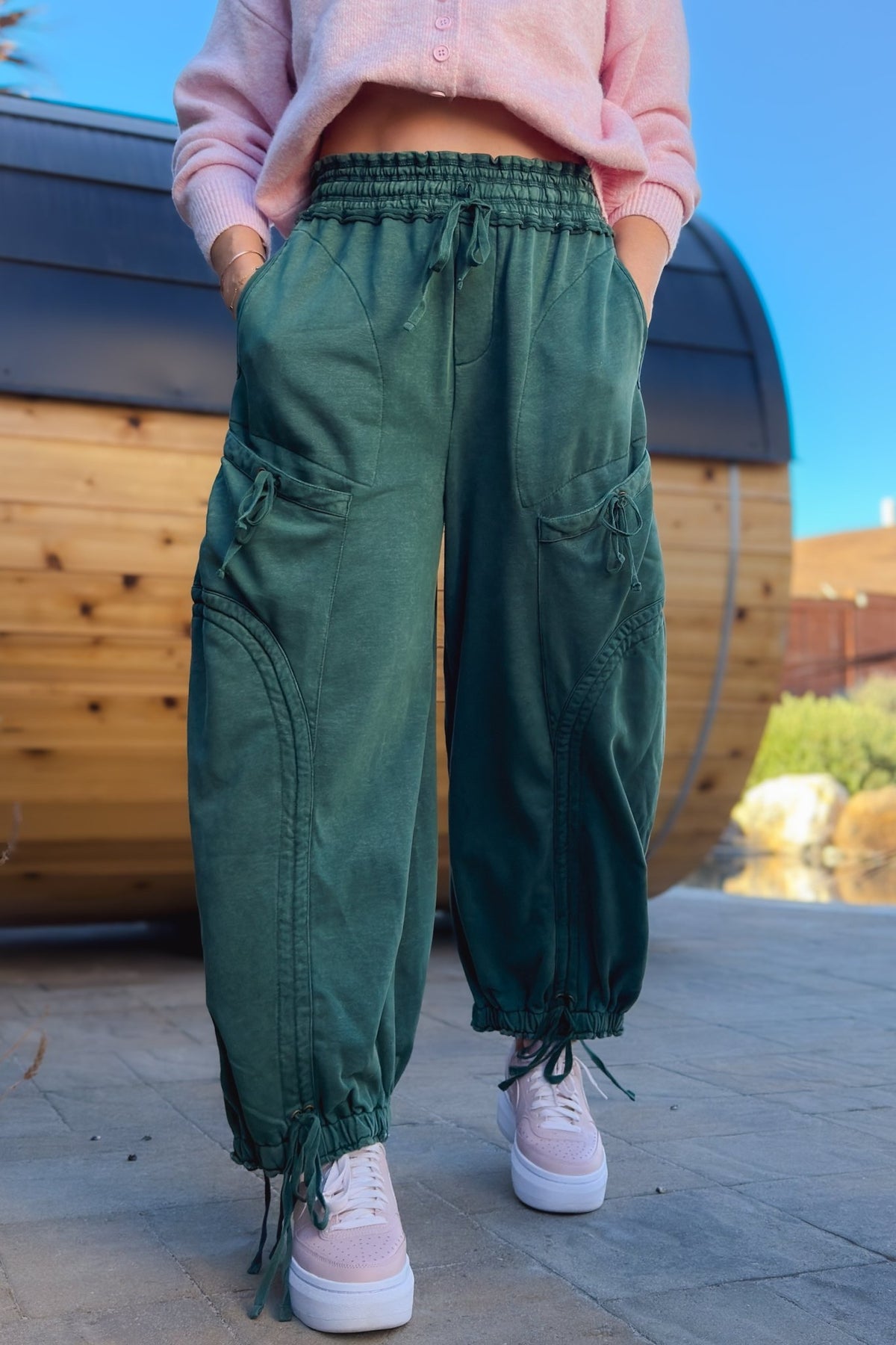 Green mineral wash wide leg cargo pants for women styled with pink cardigan and sneakers