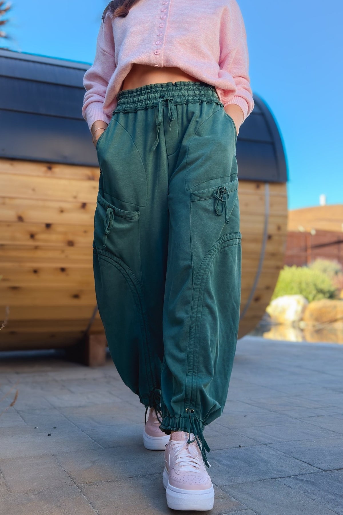 Close-up of green mineral wash cargo pants with side pockets and adjustable drawstring details