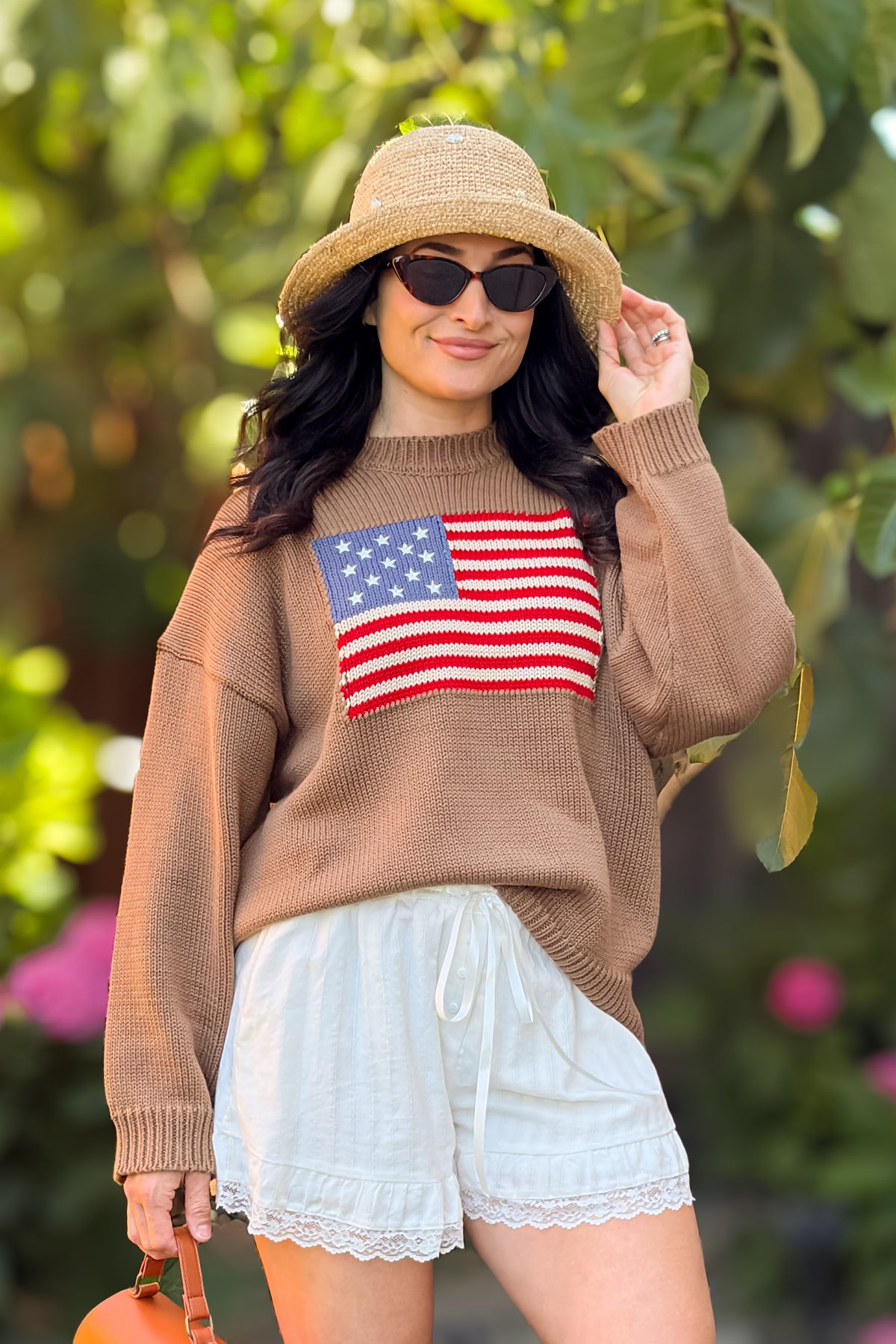 Close-up of brown heritage sweater featuring an American flag knit graphic and relaxed silhouette.