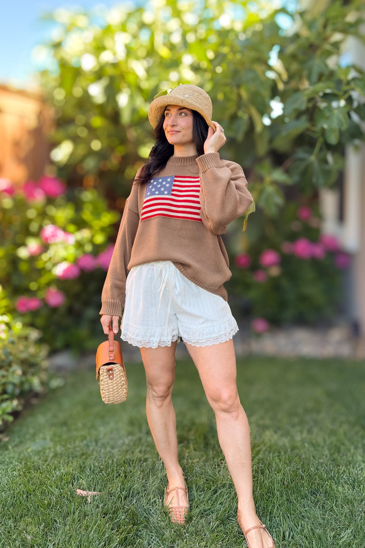 Brown American flag sweater outfit with ivory lace trim shorts and woven handbag.