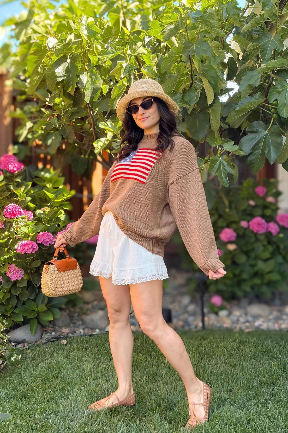Brown heritage American flag sweater styled with sunglasses and ivory lace trim shorts.