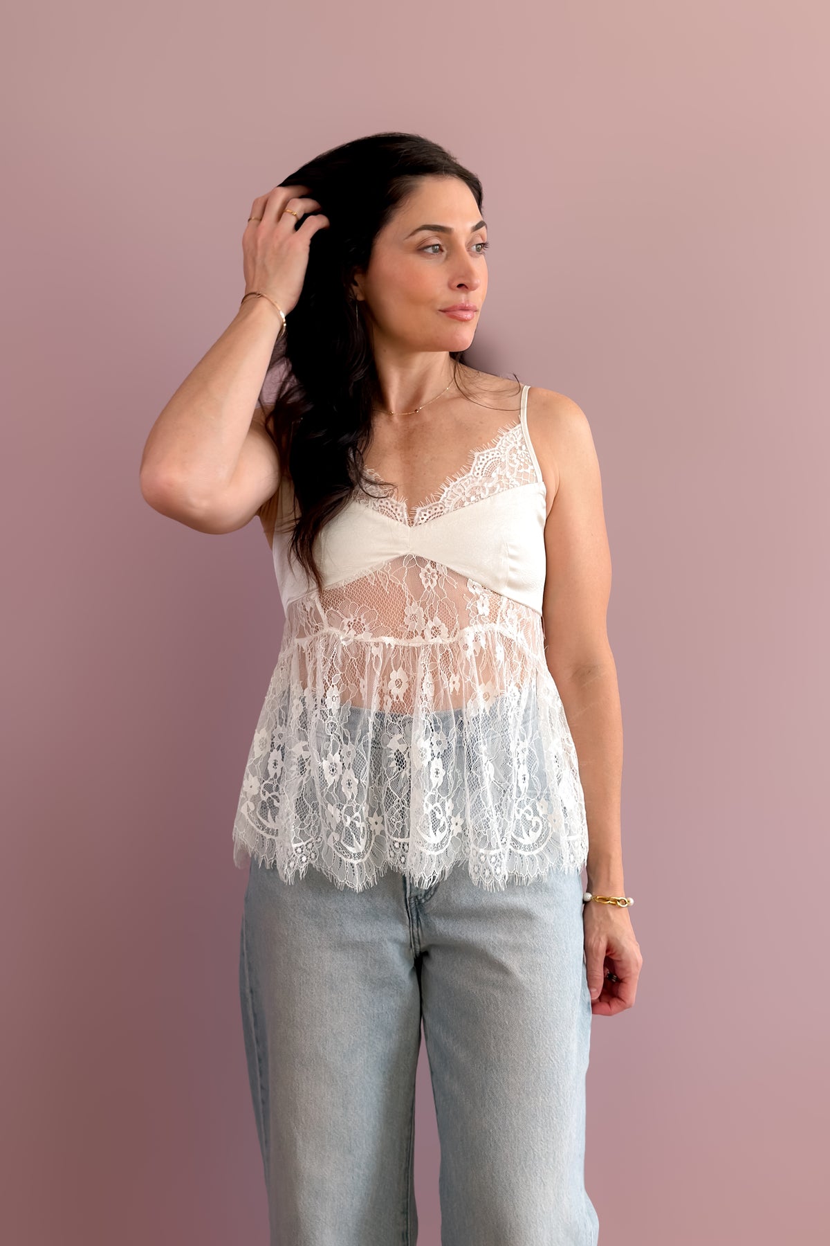 Ivory sheer lace cami top with adjustable spaghetti straps and relaxed peplum hem.