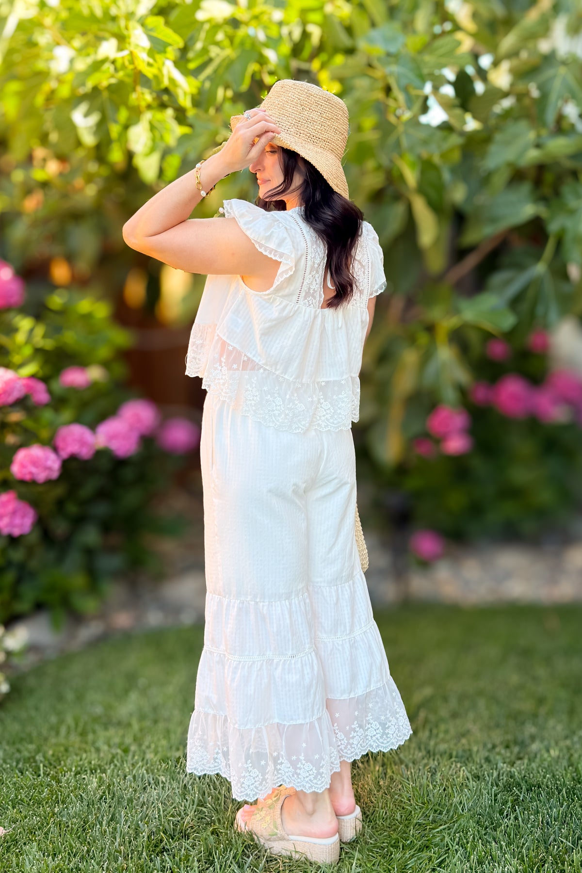 Textured ivory gingham fabric with floral lace accents on lightweight wide leg summer pants for women.