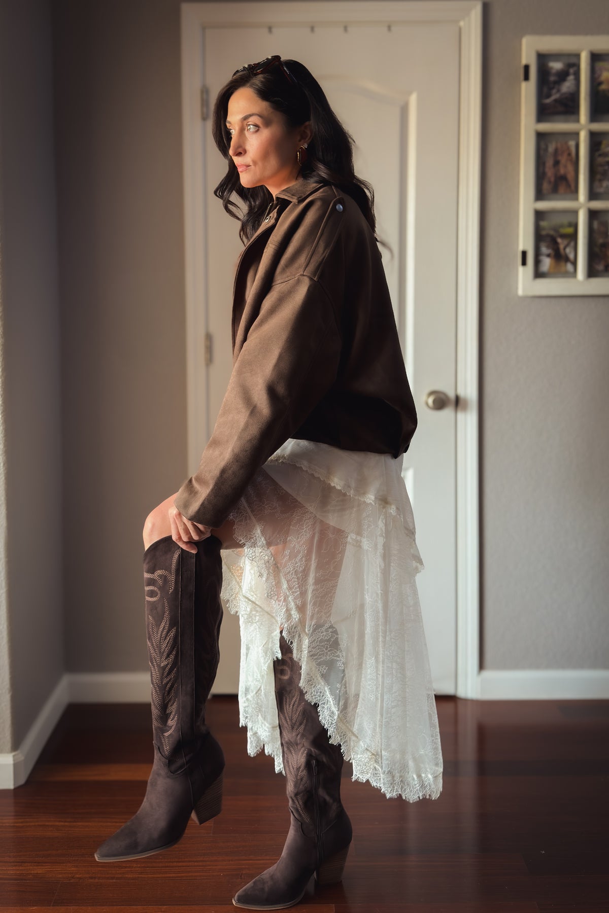Ivory lace midi dress with thin straps, layered ruffle details, and asymmetrical hem