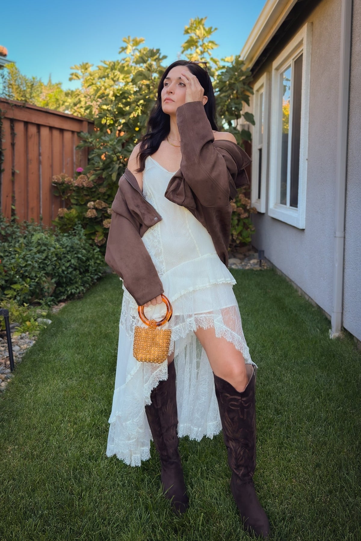 Ivory lace high low dress styled with a beaded handbag and brown western boots