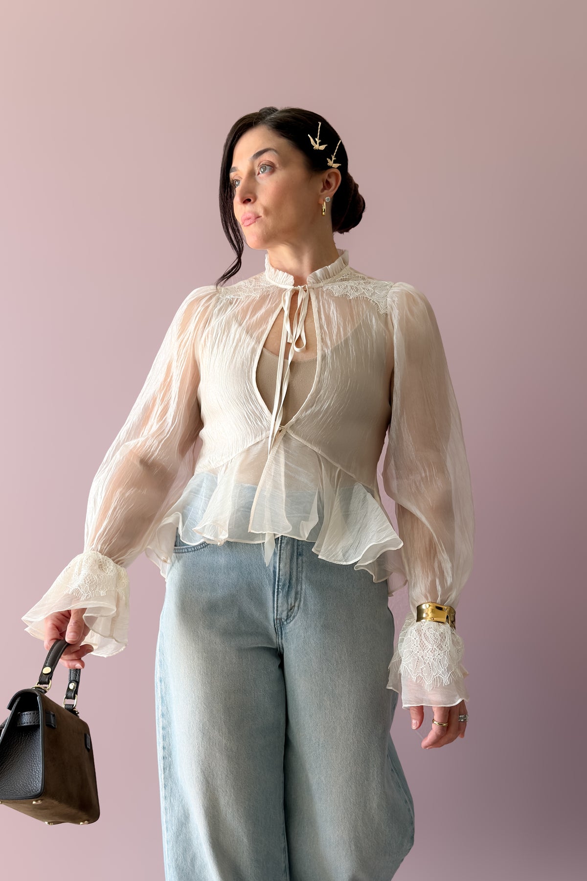 Back view of ivory sheer organza blouse showing translucent fabric and fitted peplum silhouette