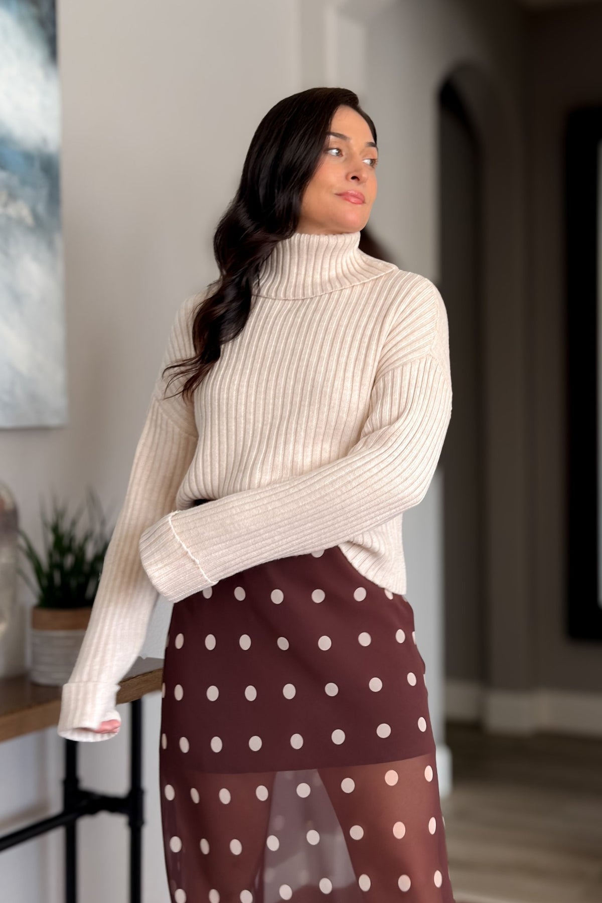 Light beige relaxed turtleneck sweater with vertical ribbing and soft drape