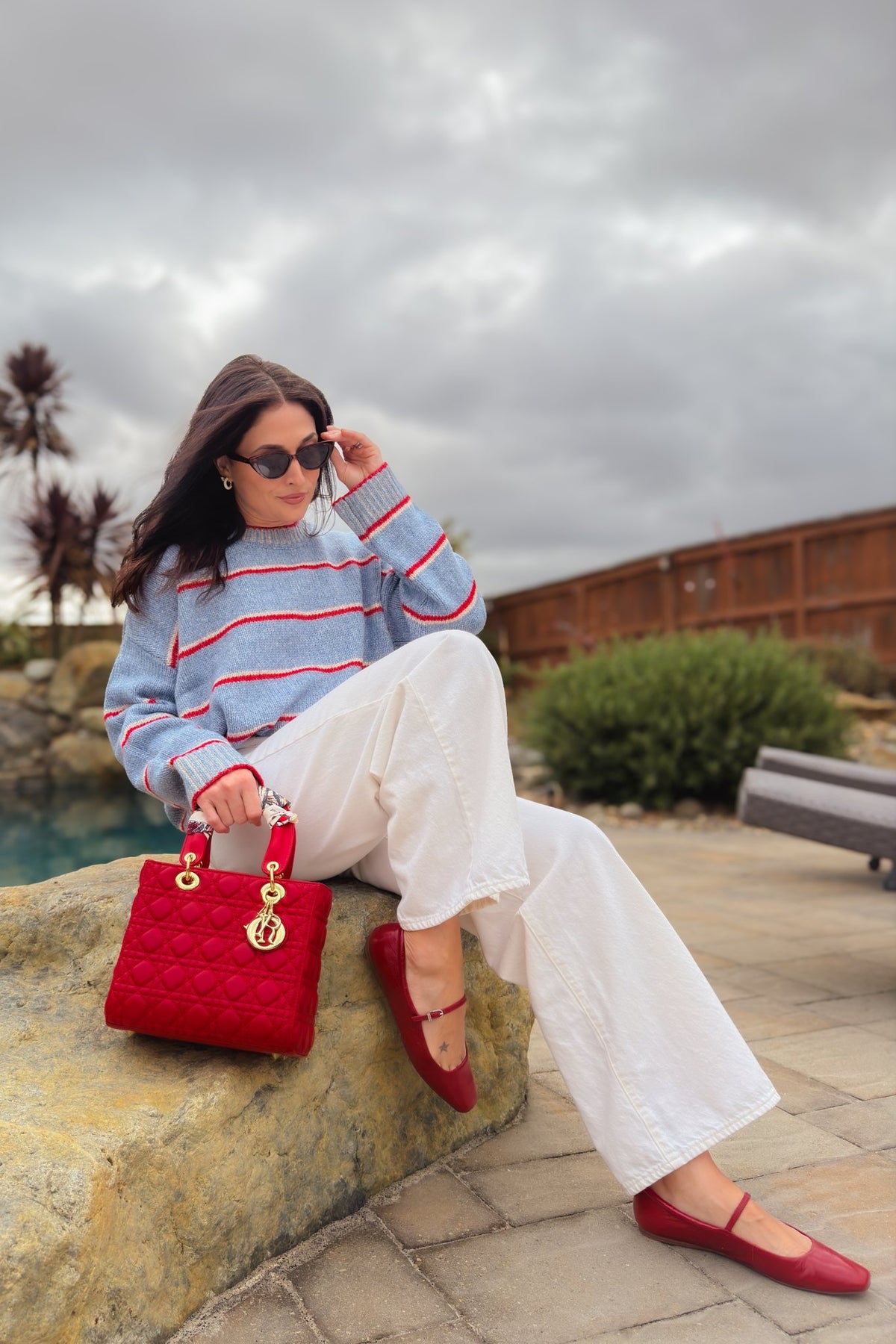 Light blue oversized sweater styled with white jeans and red flats