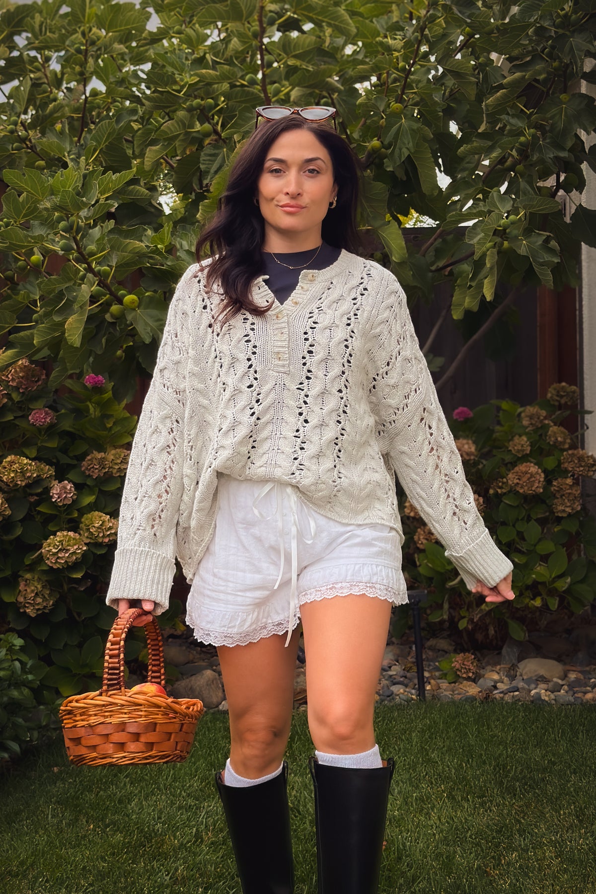 Light gray Henley sweater featuring cable knit texture, open pointelle stitching, and relaxed fit.