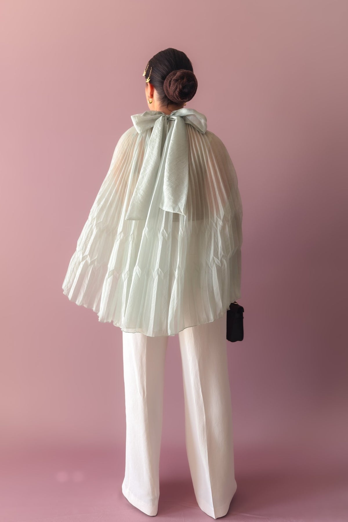 Mint pleated chiffon cape top styled separately with white wide leg trousers and brown handbag