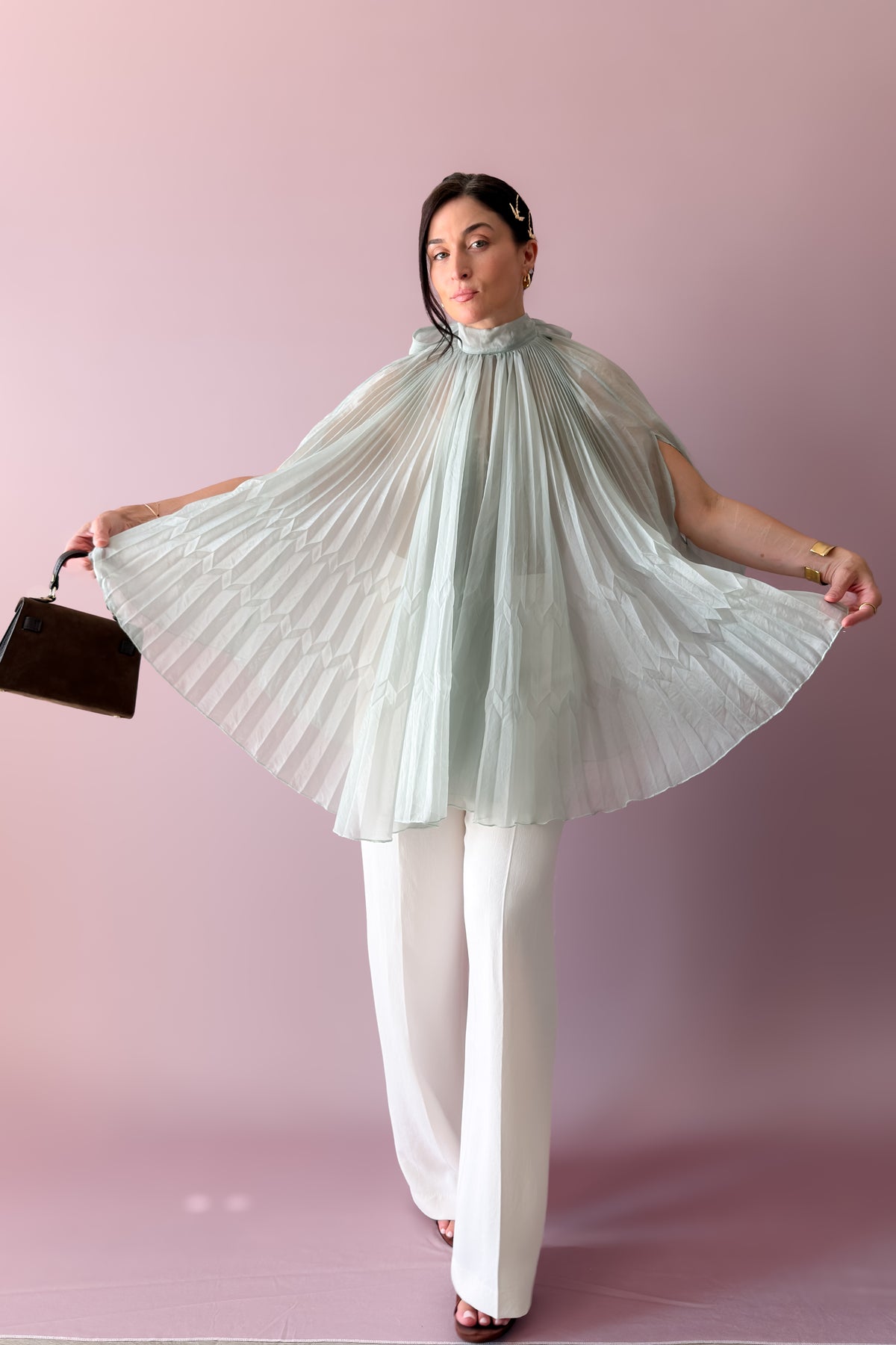 Mint pleated chiffon cape blouse styled with white trousers for an elegant special occasion outfit
