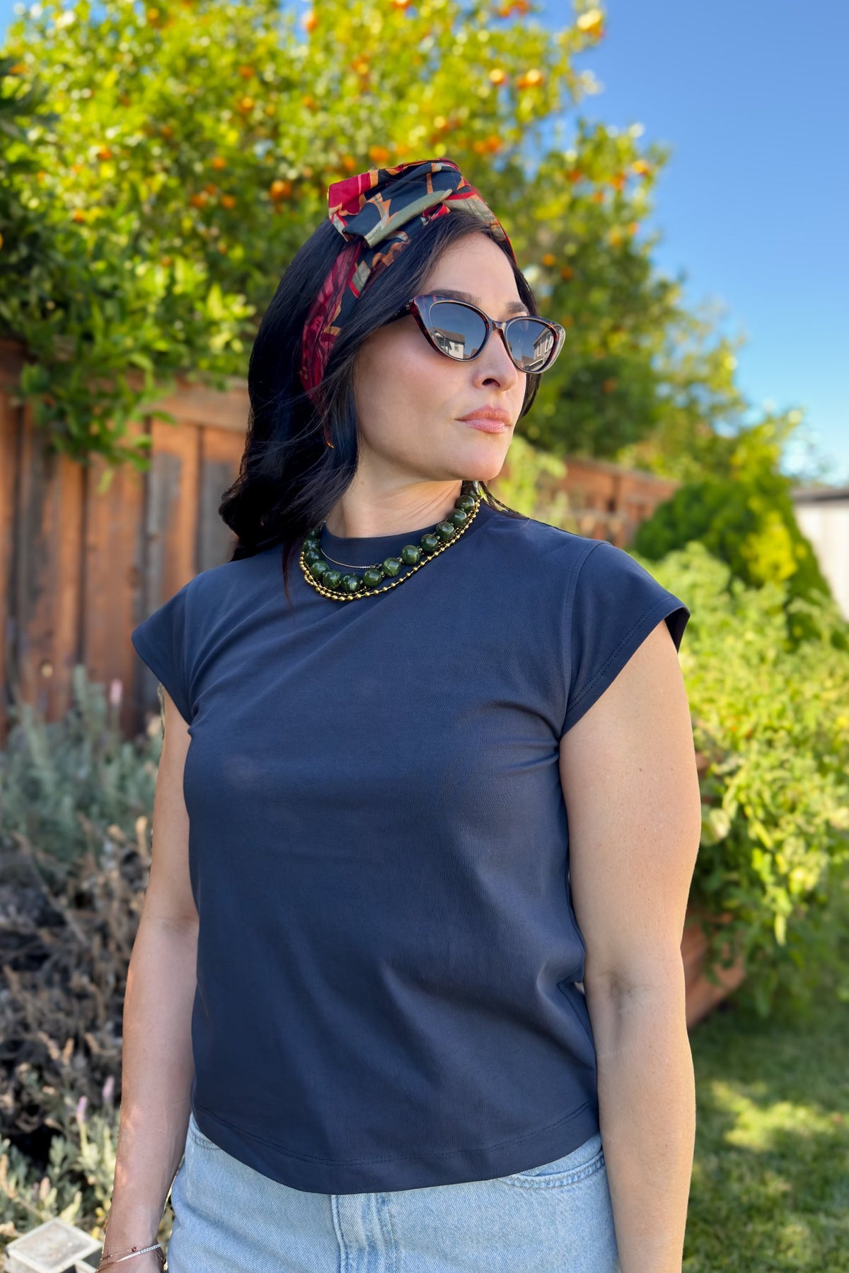 Opaque navy blue basic T-shirt paired with relaxed light wash denim for an everyday outfit.
