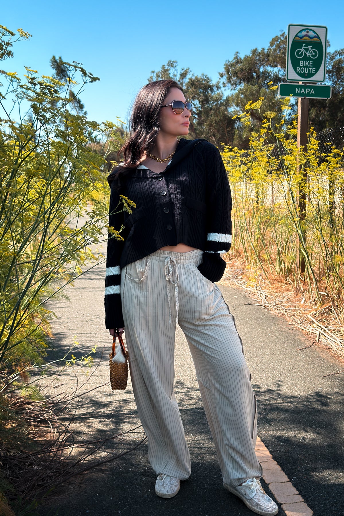 Women’s navy cardigan sweater with contrast ivory trim, cable knit design, long sleeves, and relaxed boxy fit.