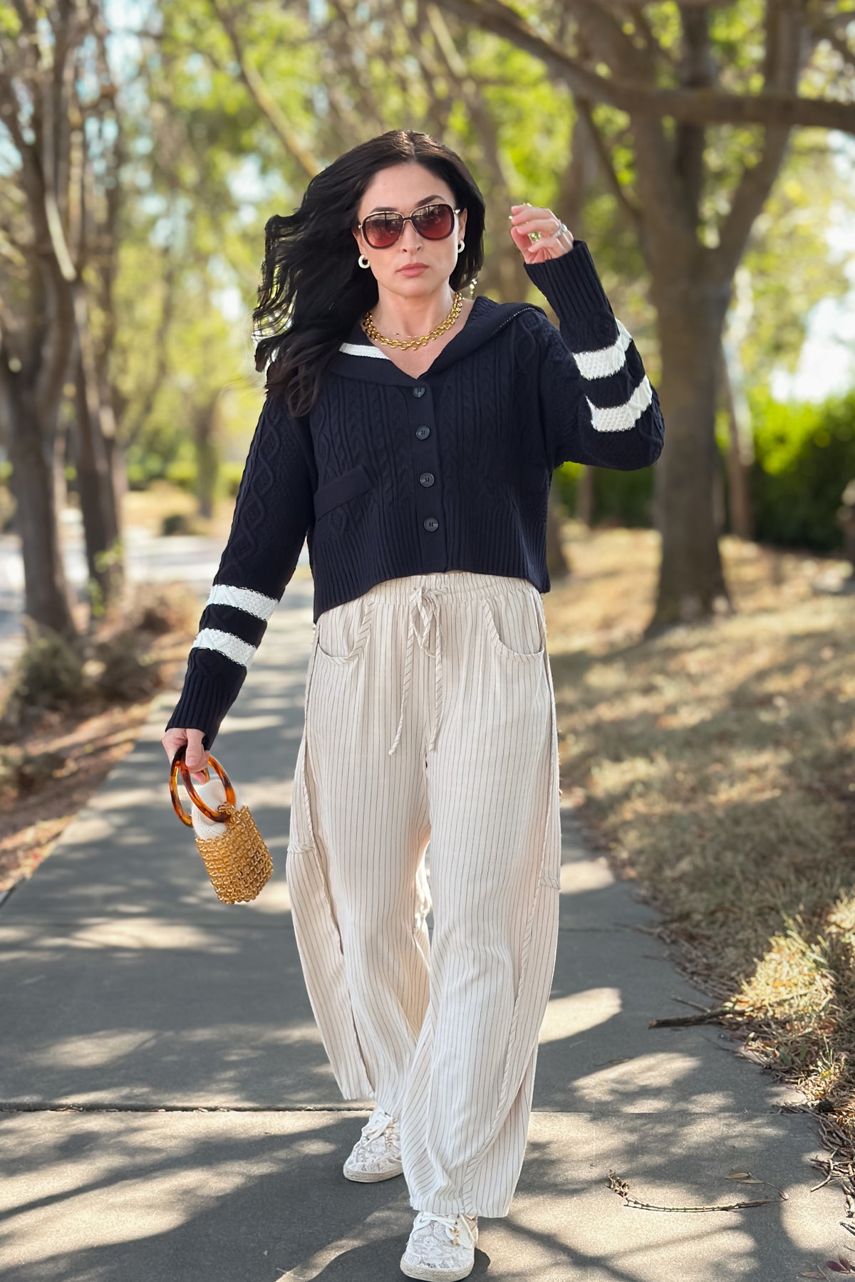 Soft navy button front cardigan featuring cable knit texture, ivory contrast collar, and relaxed cropped silhouette.