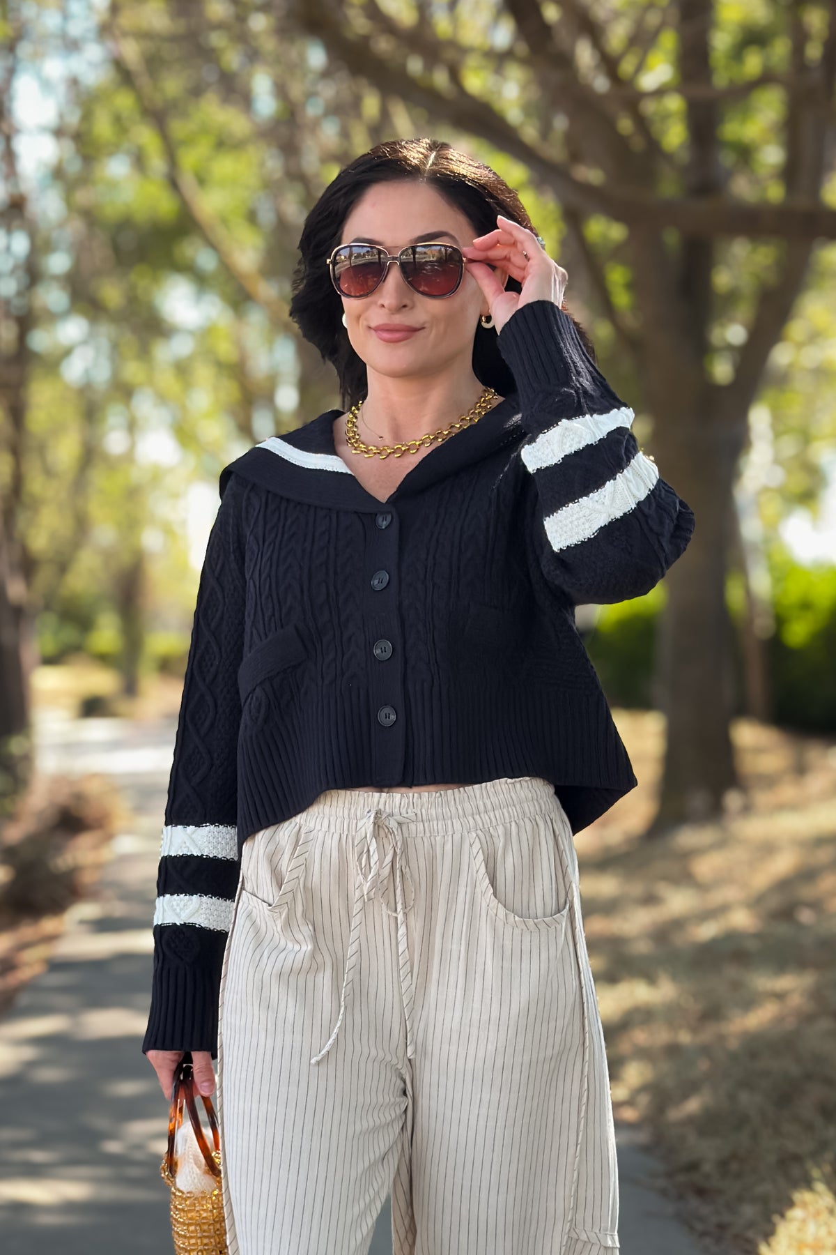 Women’s navy cable knit cardigan with oversized sailor collar, ivory trim, and slightly cropped boxy fit.
