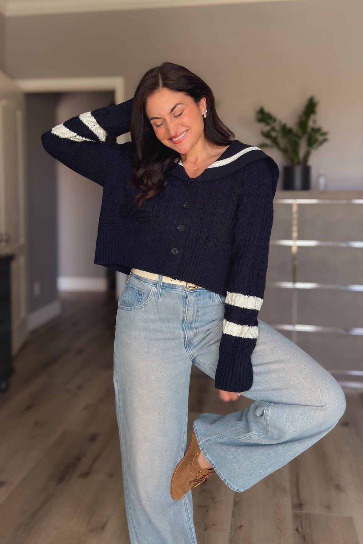 Side view of navy sailor collar cable knit cardigan showing the cropped fit, ivory contrast trim and textured navy knit.